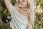 Lächelnde Frau mit langen Haaren in einer natürlichen Umgebung