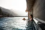 Person im Wasser mit Berglandschaft im Hintergrund