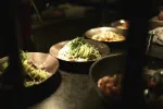 Bowls of various dishes on a dark table