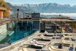 Swimming pool area with loungers and mountains in background