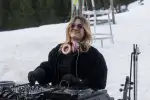 DJ in schwarzer Jacke auf Schnee mit Kopfhörern