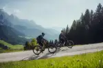 Zwei Radfahrer auf einem Schotterweg in einer Berglandschaft