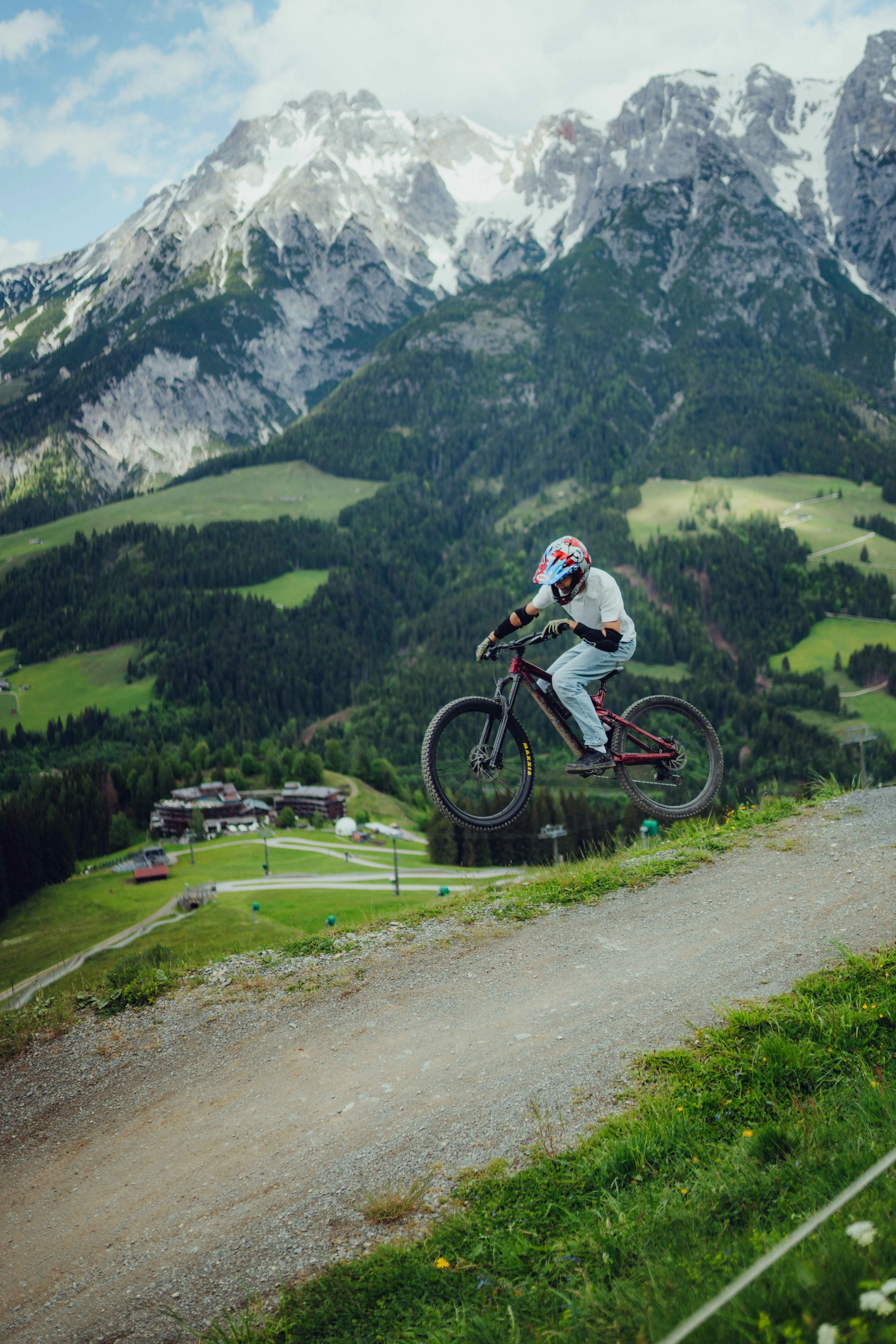 Mountainbiker springt in den Alpen über einen Abhang bei Leogang.