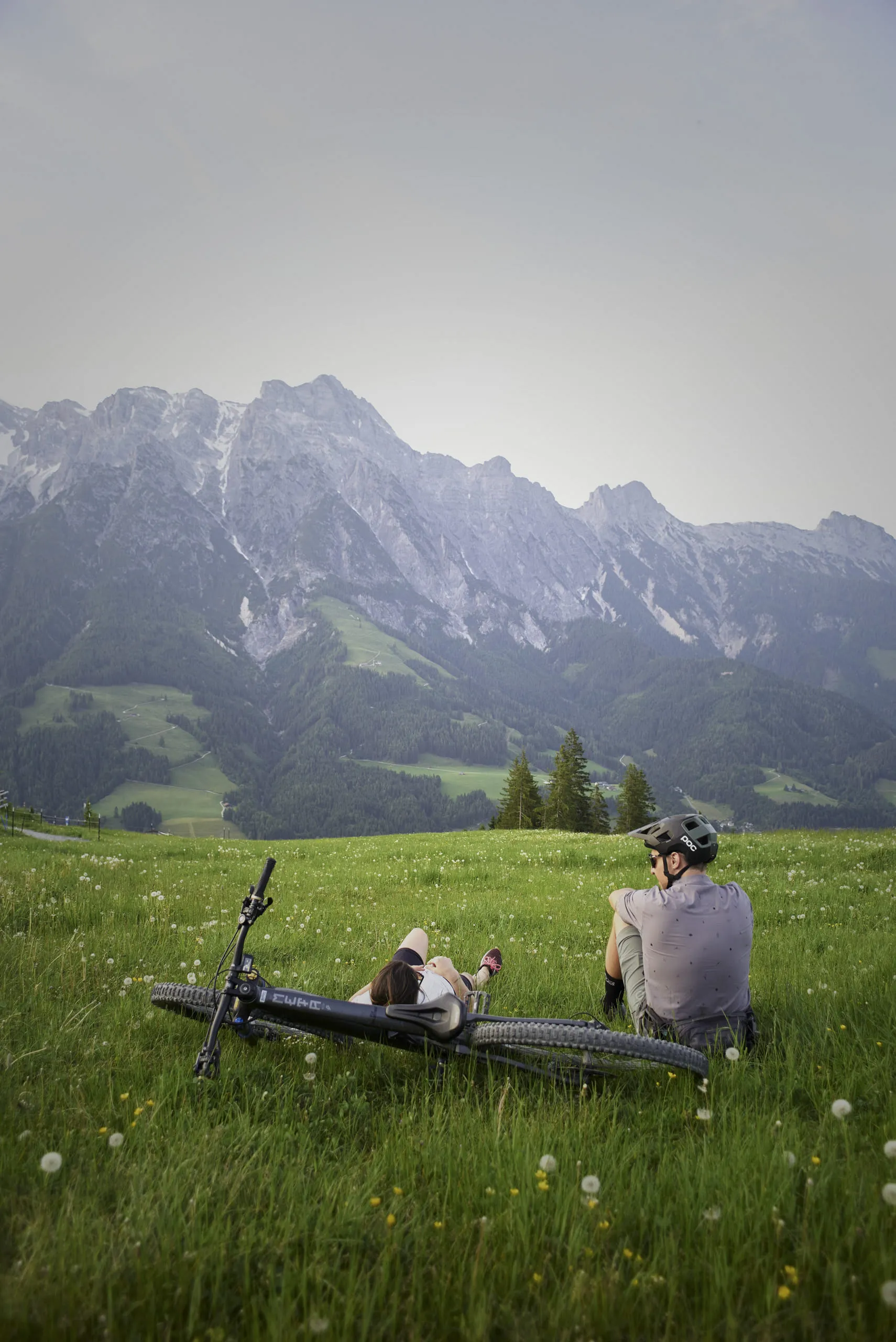 Biker entspannt auf einer Wiese mit Bergpanorama in Leogang.