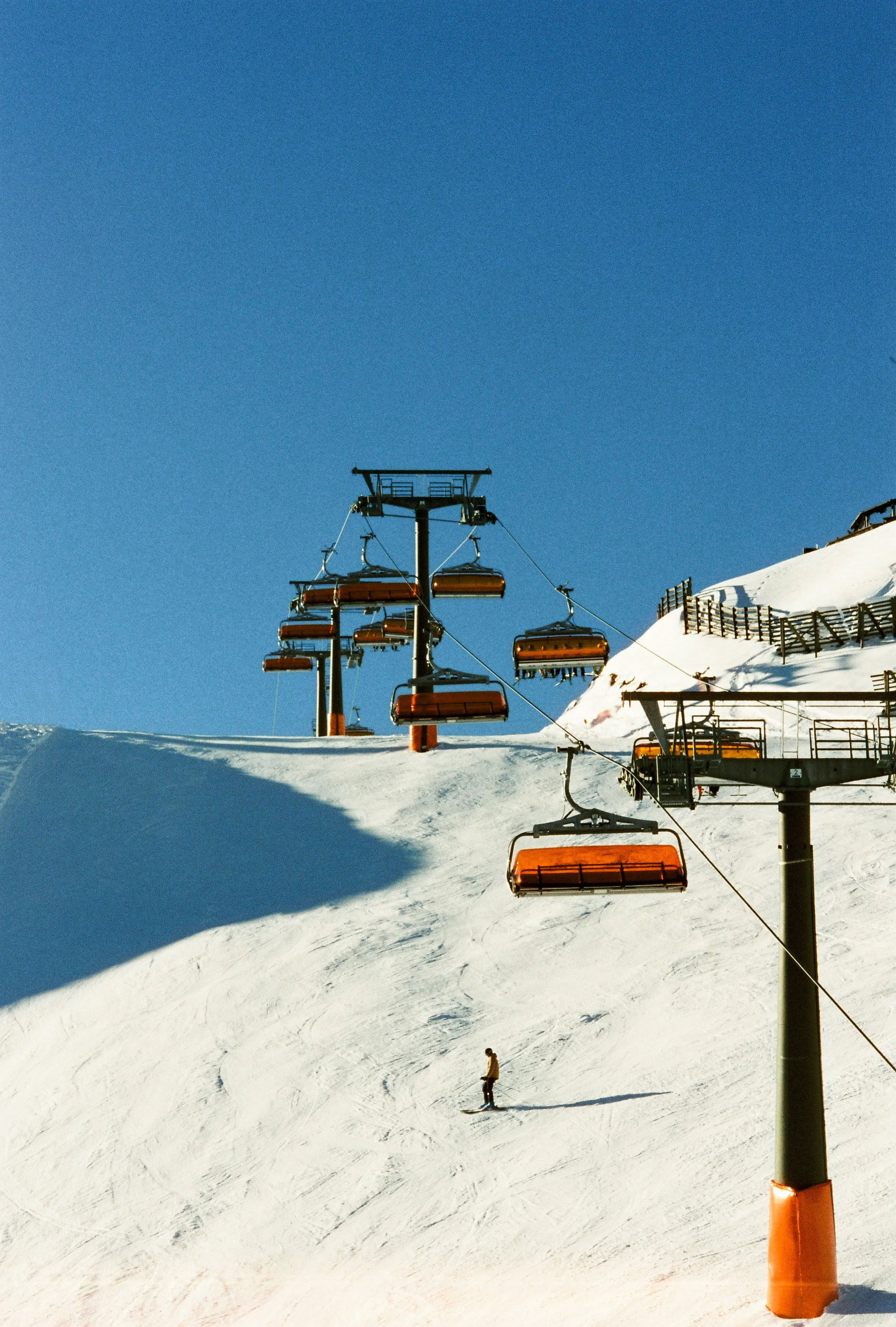 Skilift mit Pistenarbeiter in Leogang bei klarem Himmel