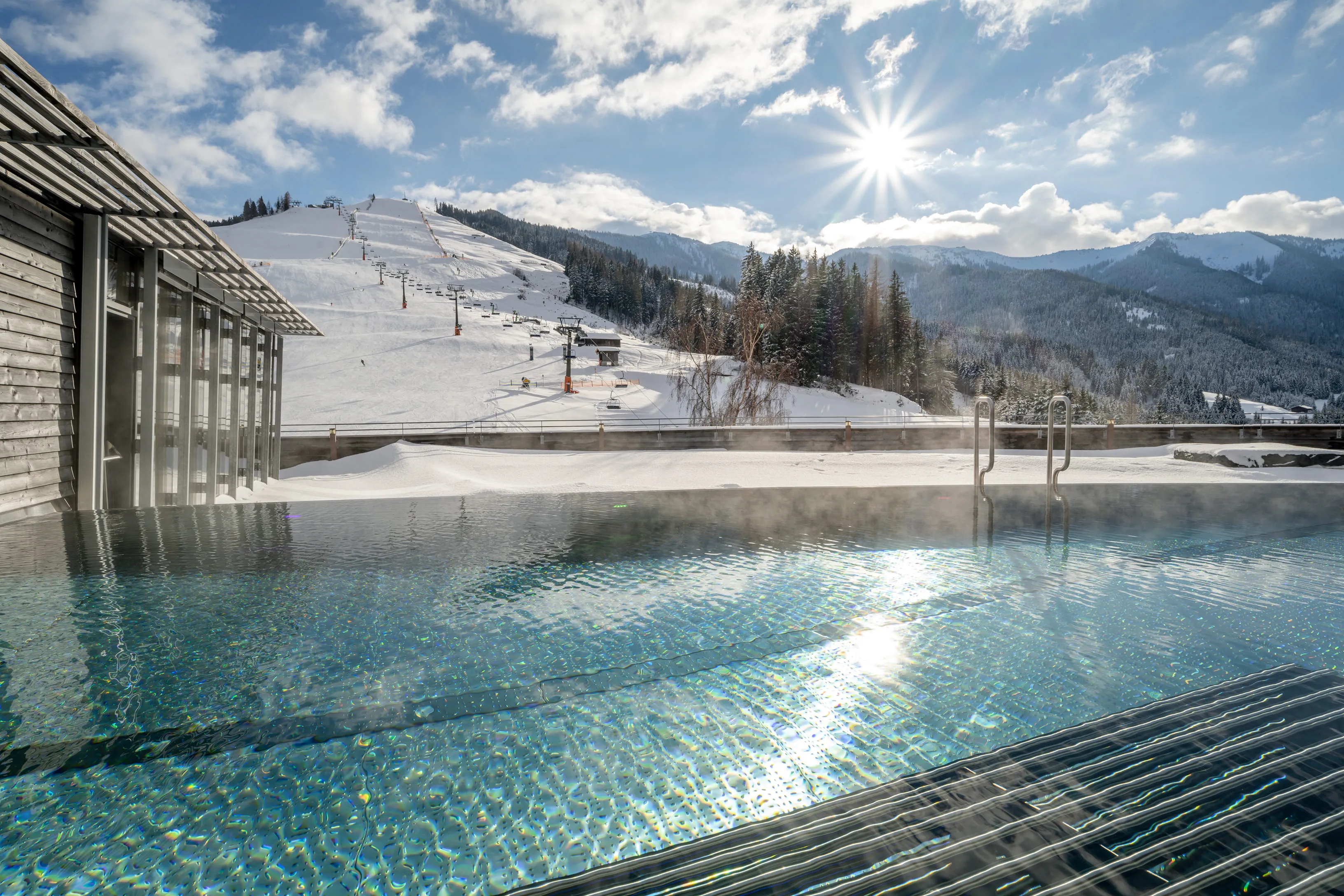 Infinity pool with mountain view and snow in Leogang