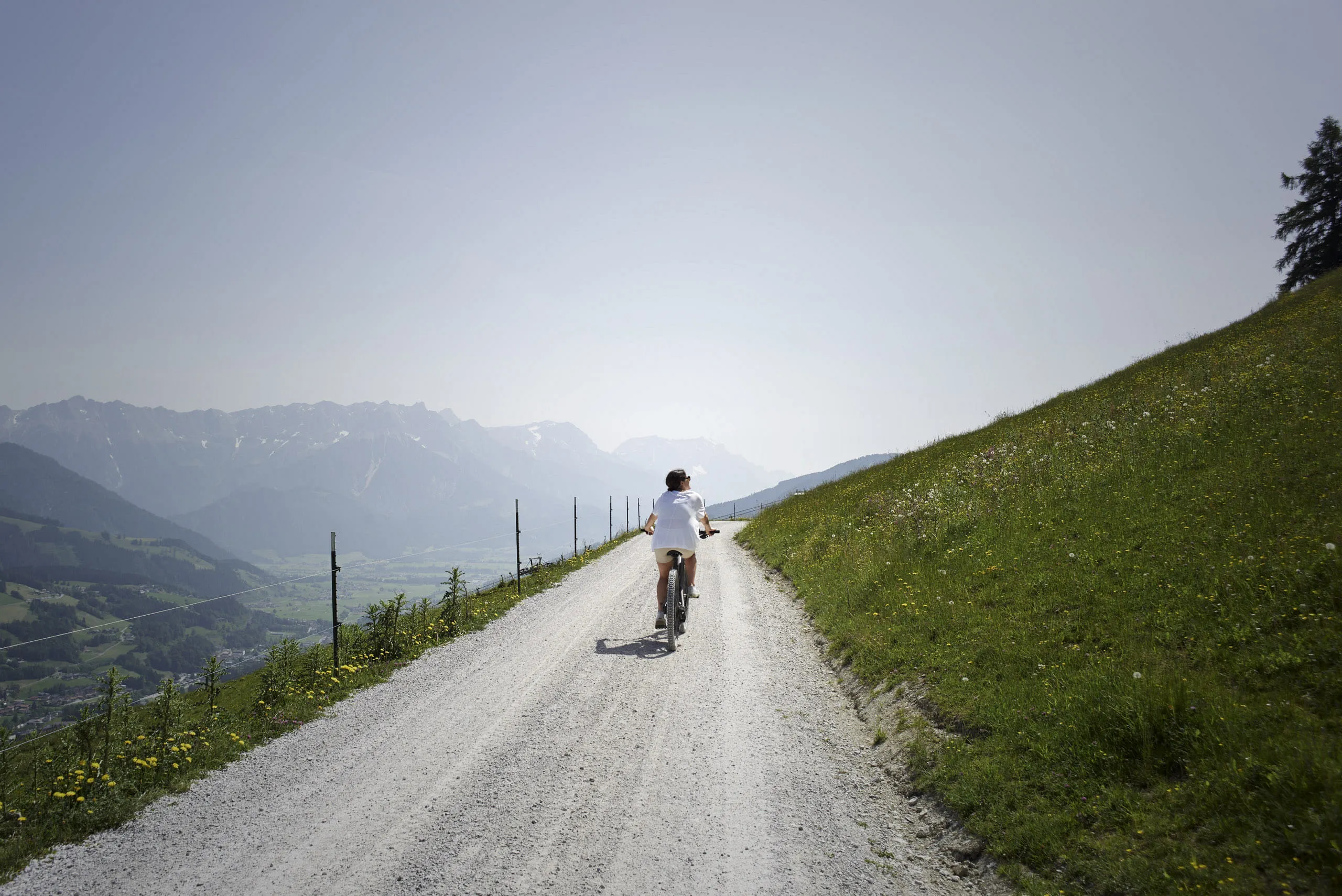 Mann fährt mit dem Fahrrad auf einem Schotterweg in Leogang.