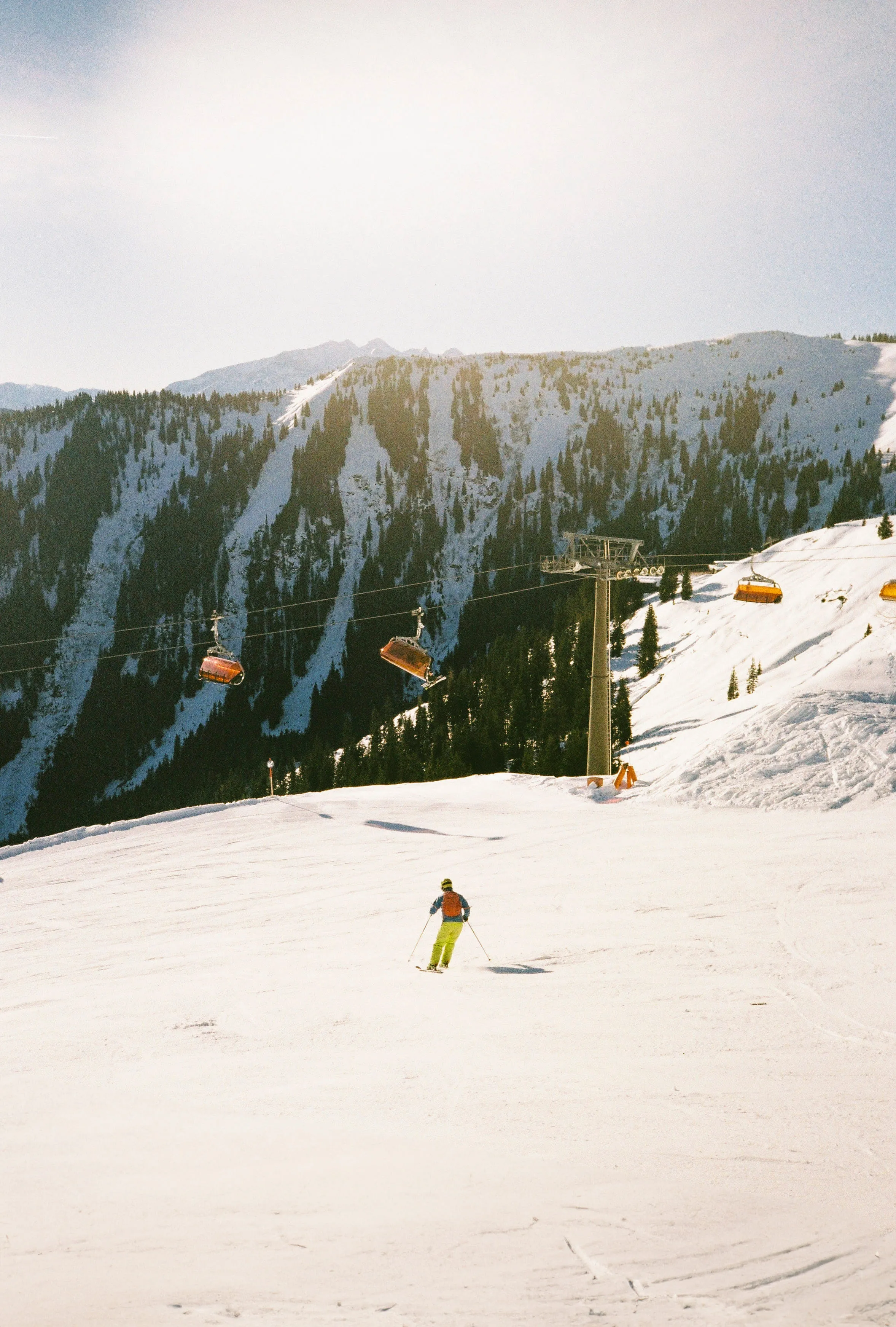Skifahrer auf einer Piste in Leogang mit Berglandschaft im Hintergrund