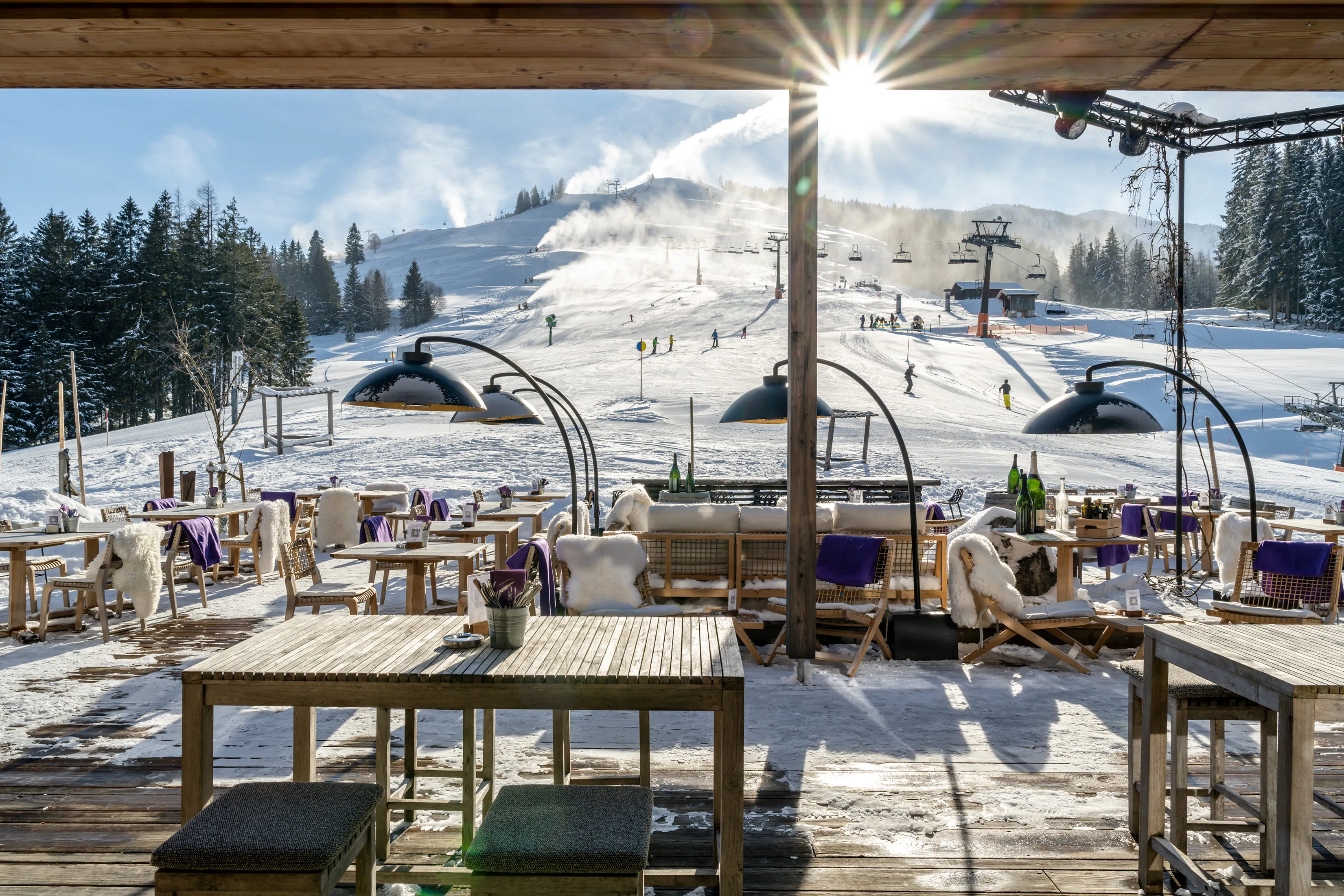 View of ski slope with seating area at Holzhotel Forsthofalm, Leogang.