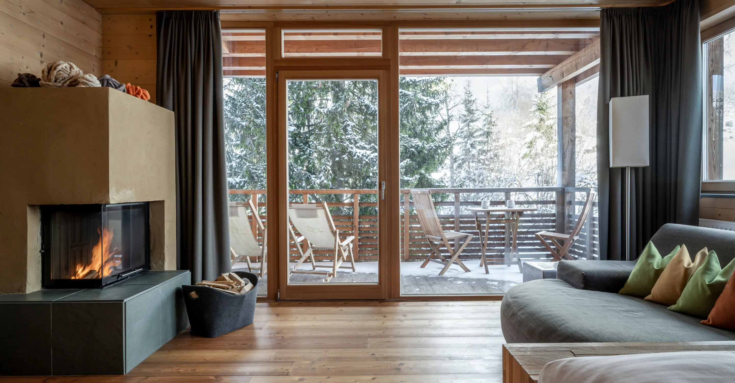 Heller Wohnraum mit Kamin und Blick auf die Terrasse im Freien