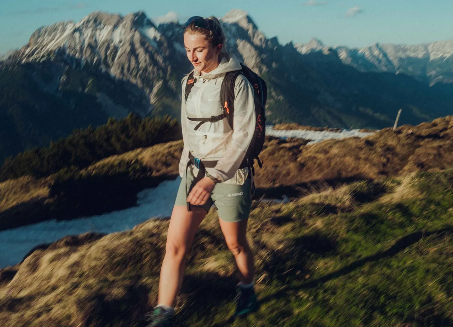 Hiker on a mountain trail with a view of the Alps