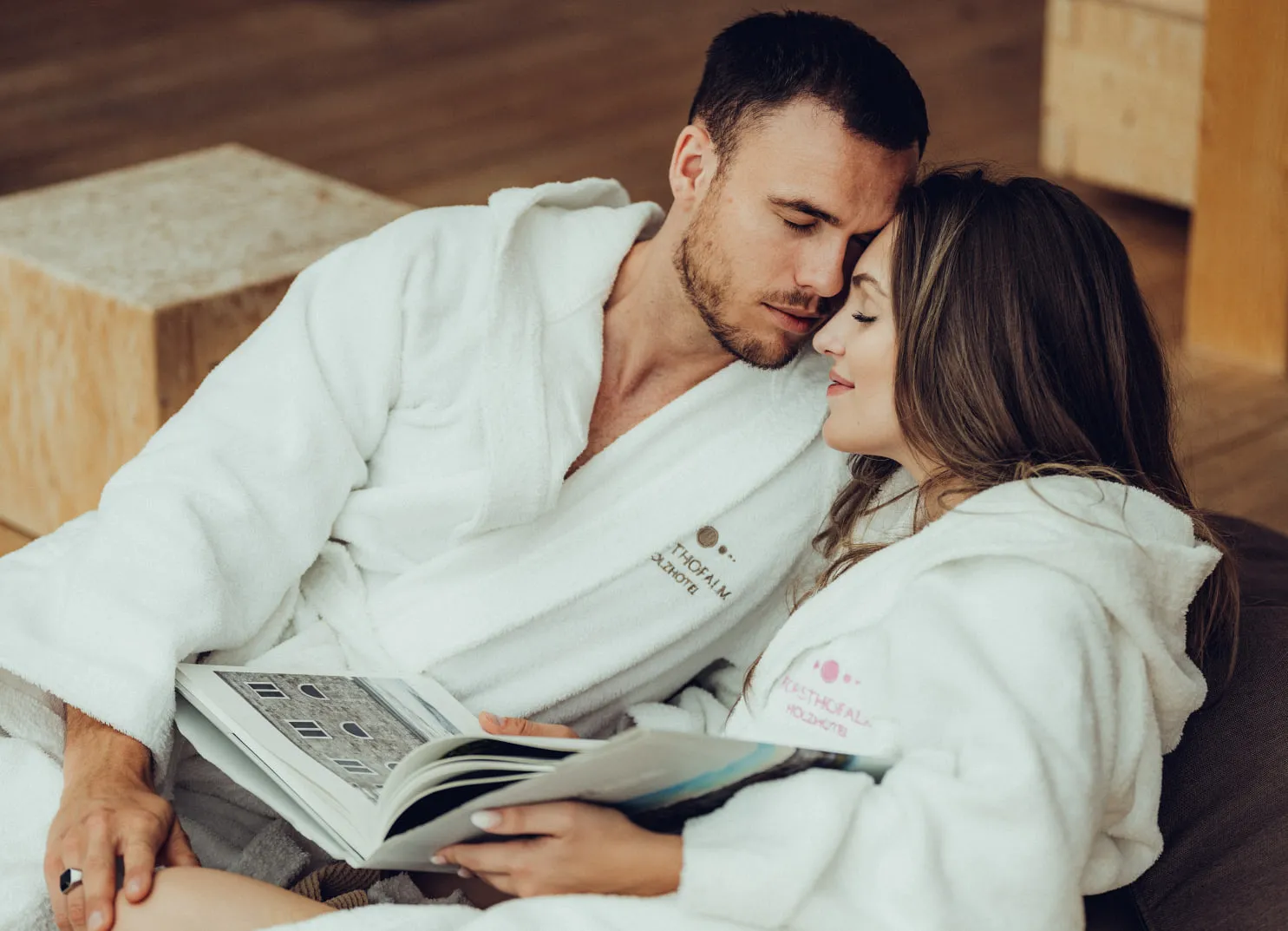 Couple in bathrobes reading a book together