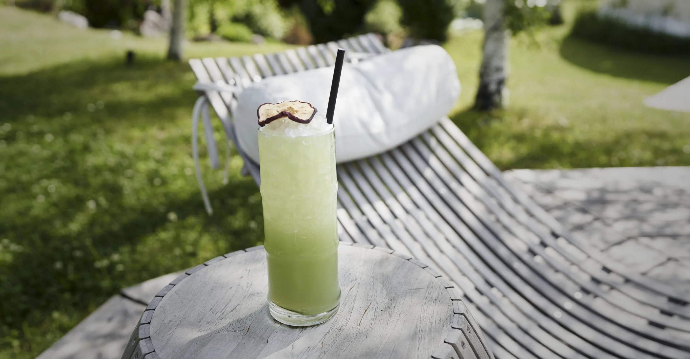 Grüner Cocktail auf einem Tisch im Holzhotel Forsthofalm.