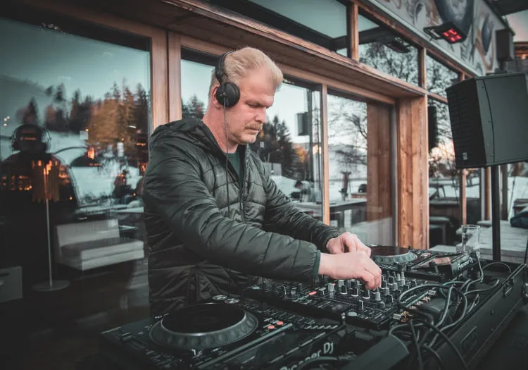 DJ at the turntables in Forsthofalm with mountain view