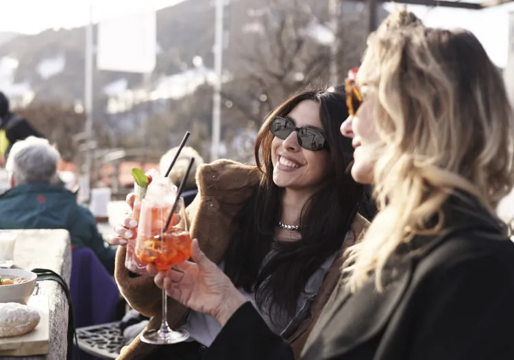 Two women enjoying cocktails at Holzhotel Forsthofalm in Leogang.