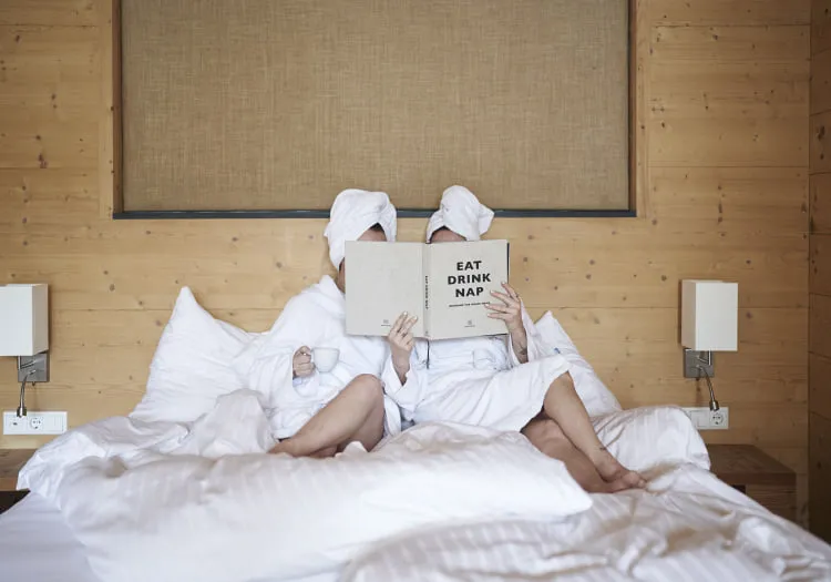 Two people in bathrobes with towels on their heads at Forsthofalm wooden hotel