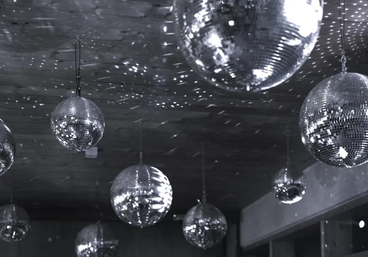 Disco balls hanging from the ceiling, reflecting lights in the room.