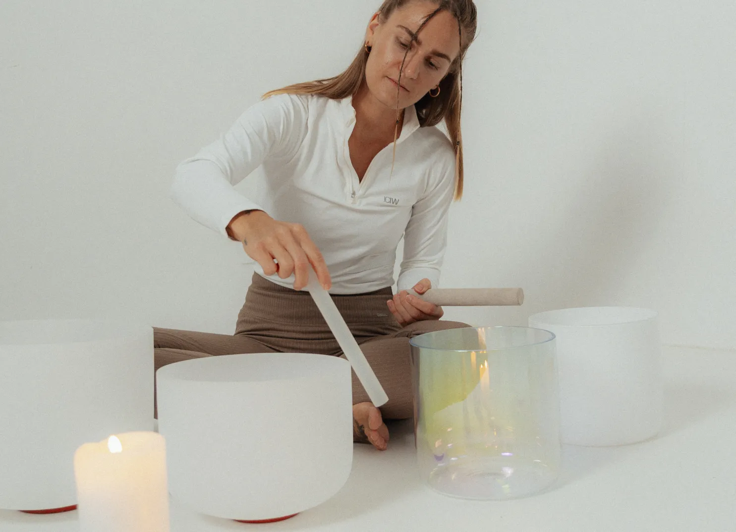 Frau spielt mit einem Mallet auf Quarzsinging-Schalen drinnen