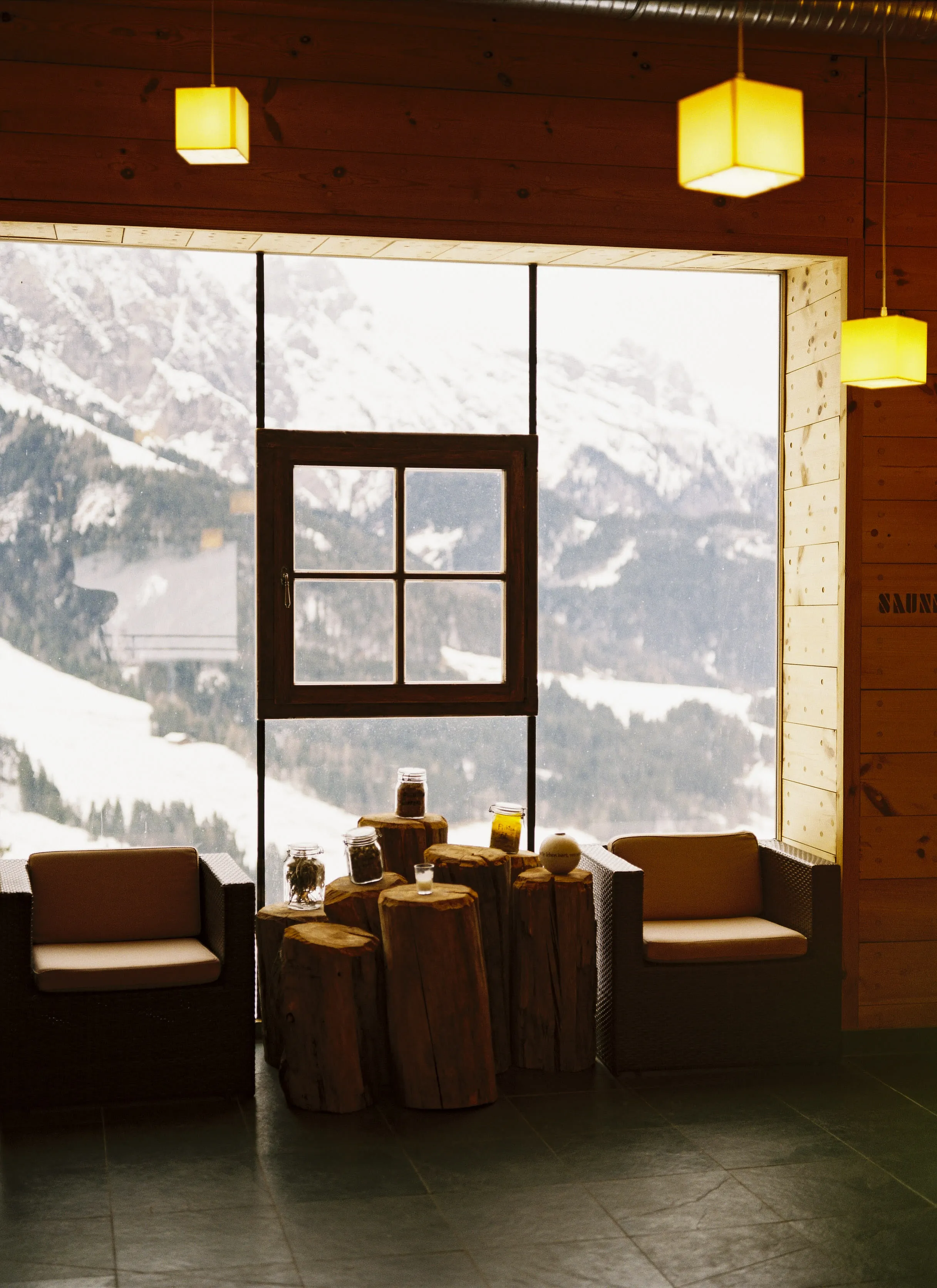 Innenansicht des Holzhotels Forsthofalm mit Blick auf schneebedeckte Berge.