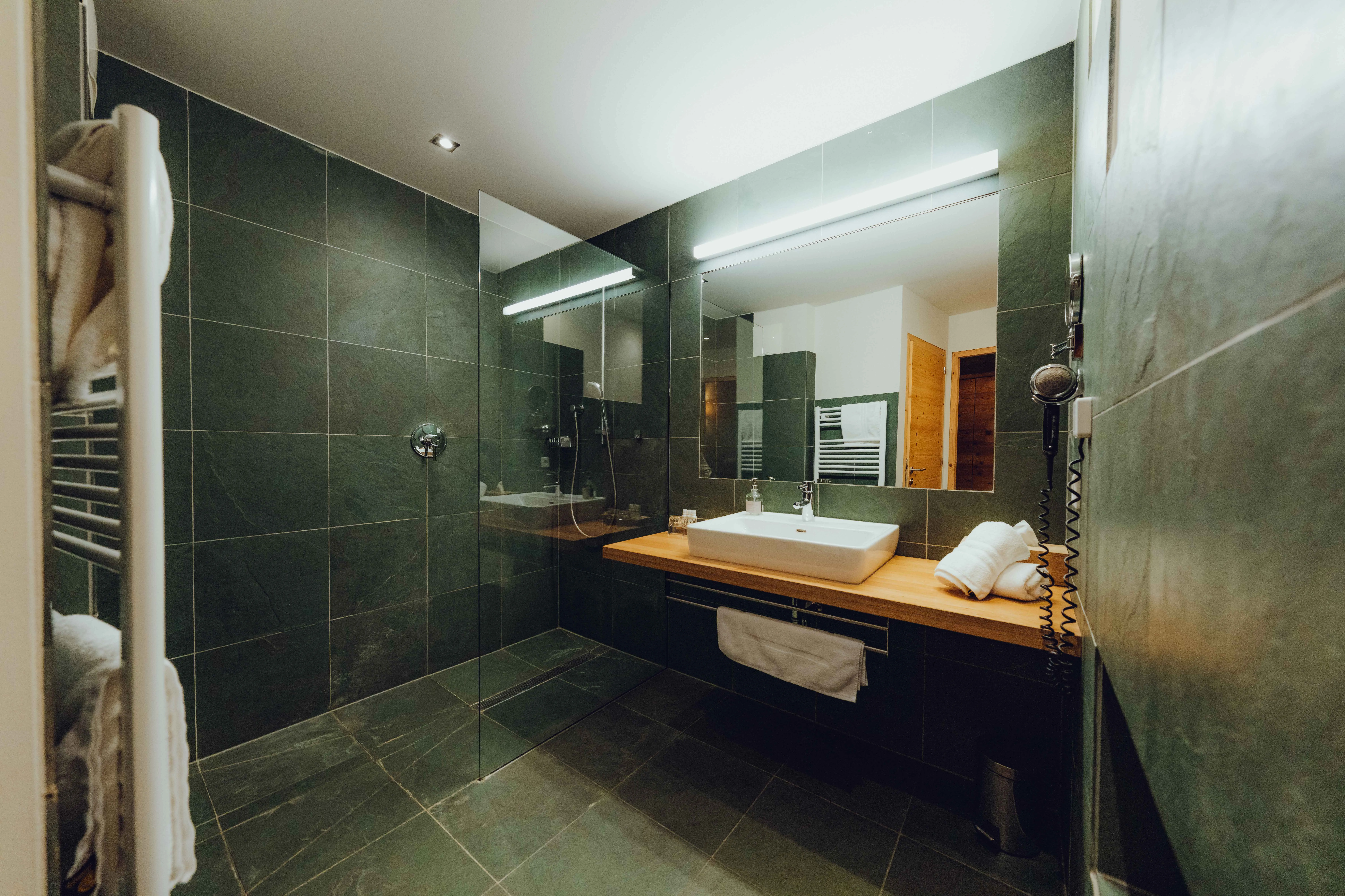 modernes Badezimmer mit dunklen Fliesen und Waschbecken