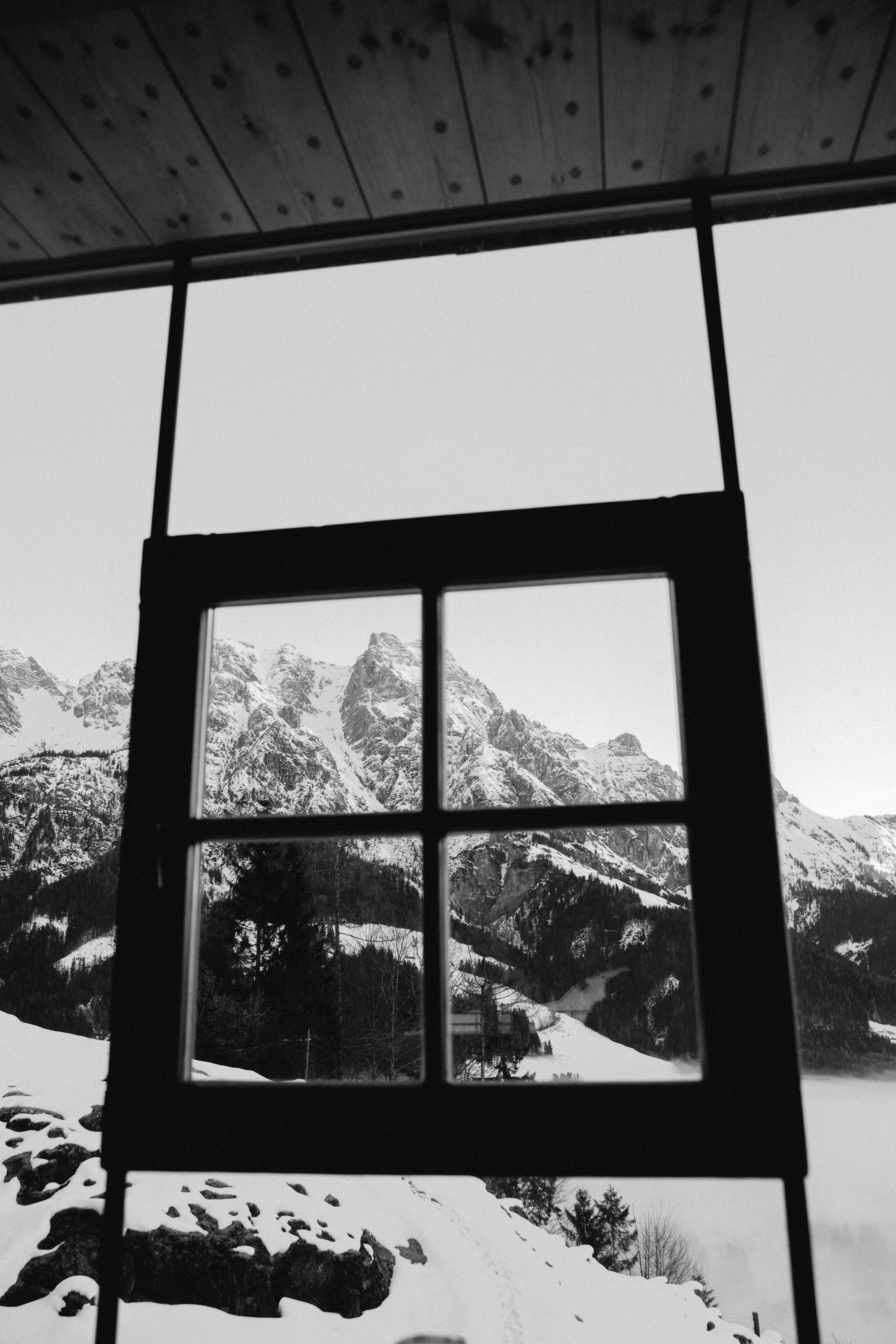 Fenster mit Blick auf schneebedeckte Berge und Landschaft