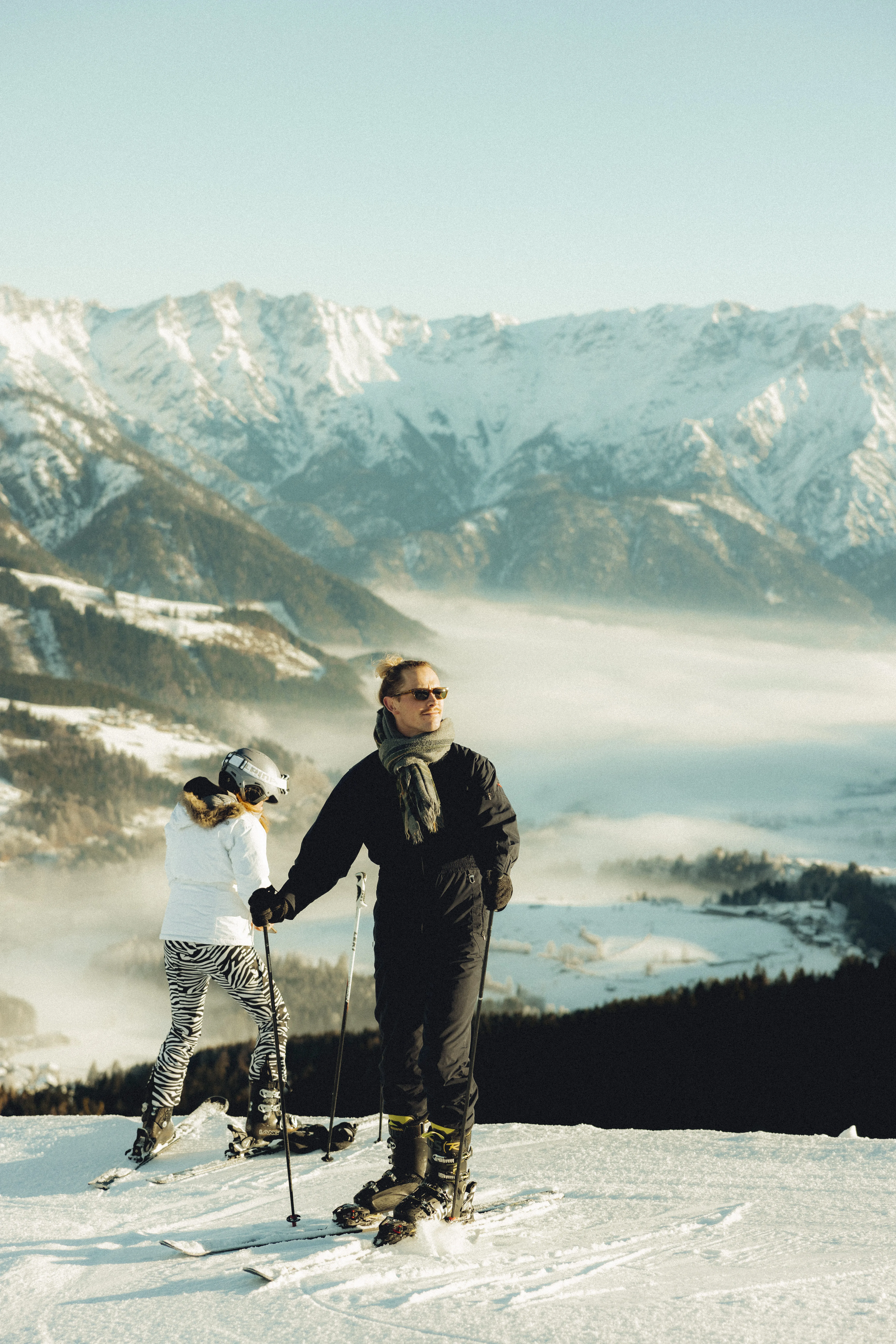 Skifahrer auf verschneitem Berg mit Alpenlandschaft im Hintergrund