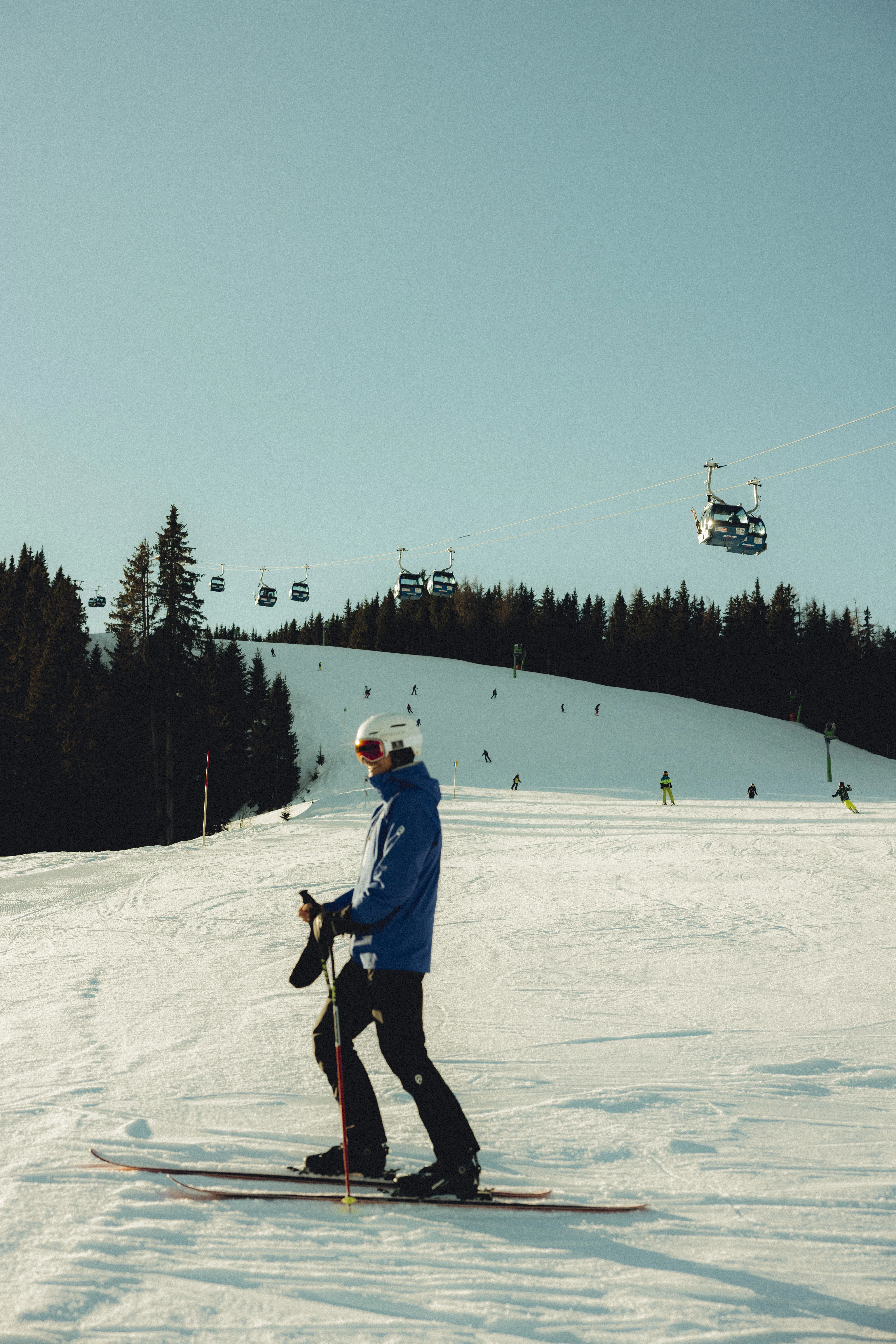 Skifahrer auf der Piste der Forsthofalm mit Seilbahnen im Hintergrund