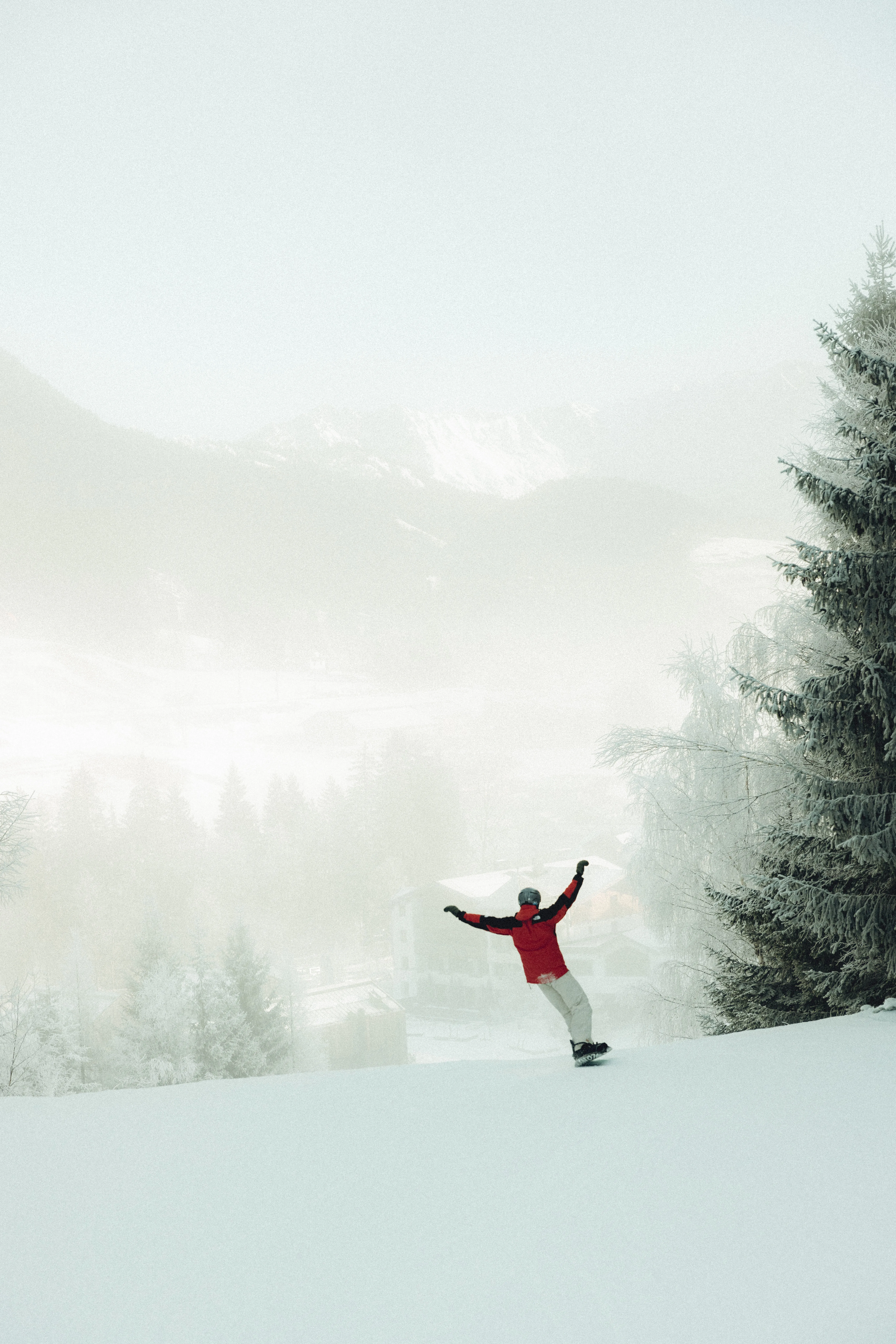 Skifahrer auf einer verschneiten Piste mit Bergen im Hintergrund