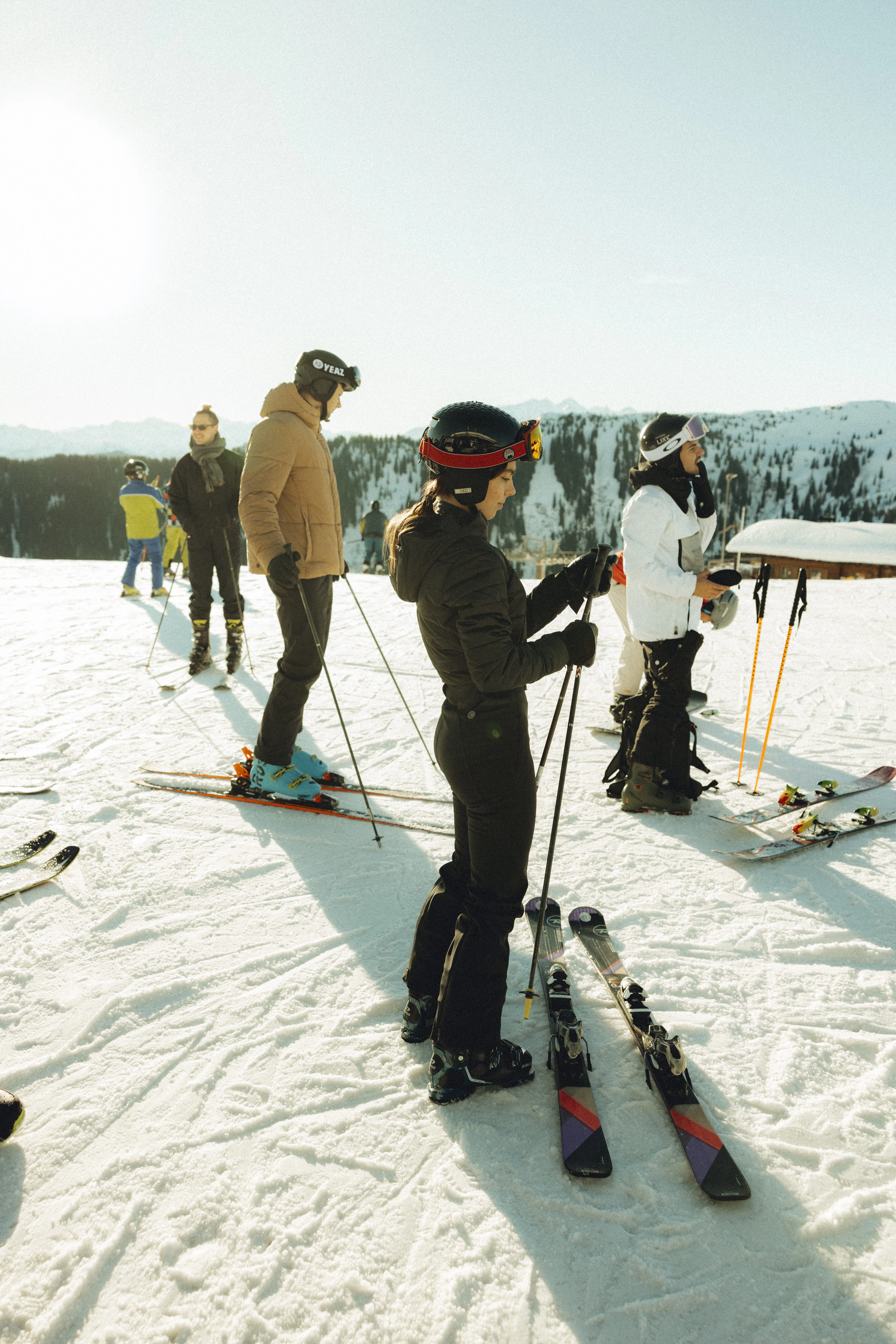 Skifahrer auf einer Schneepiste mit Bergen im Hintergrund