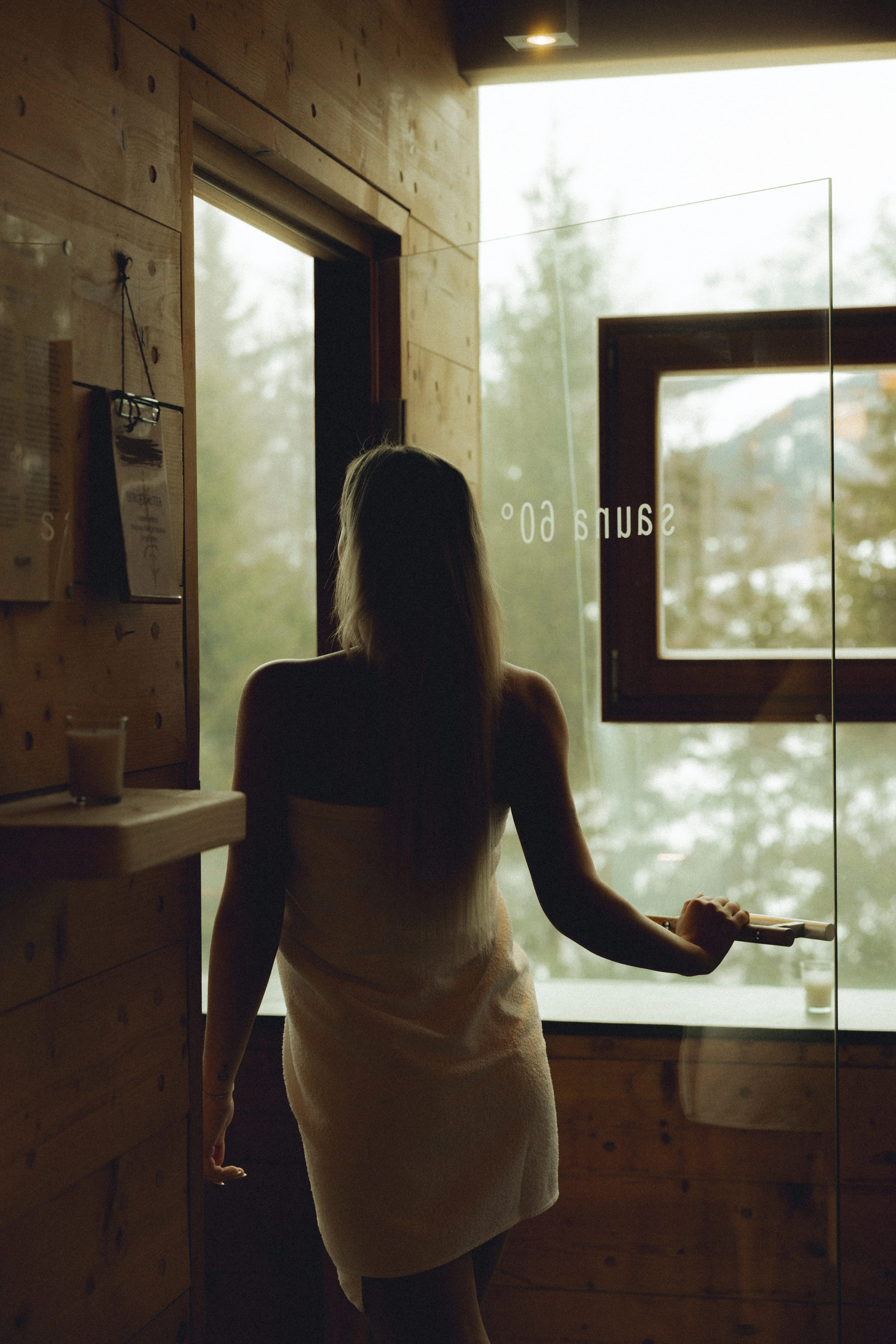 Woman in a towel by the window in Forsthofalm sauna