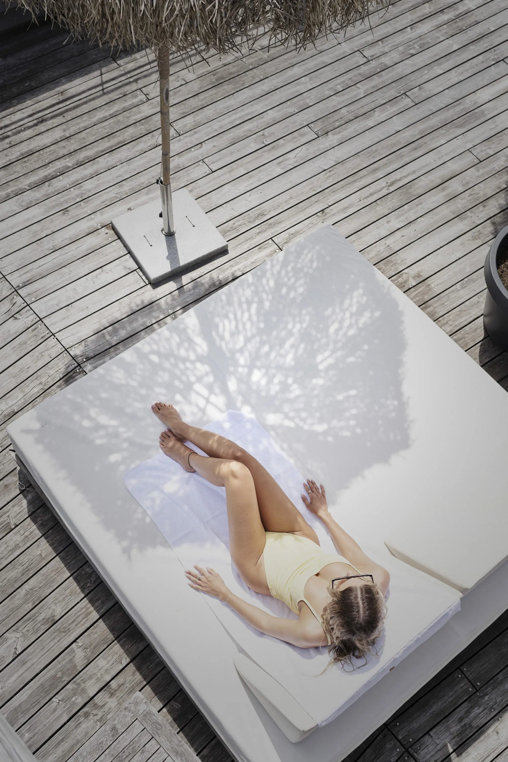 Woman in a yellow swimsuit on a lounge chair at Holzhotel Forsthofalm, Leogang.