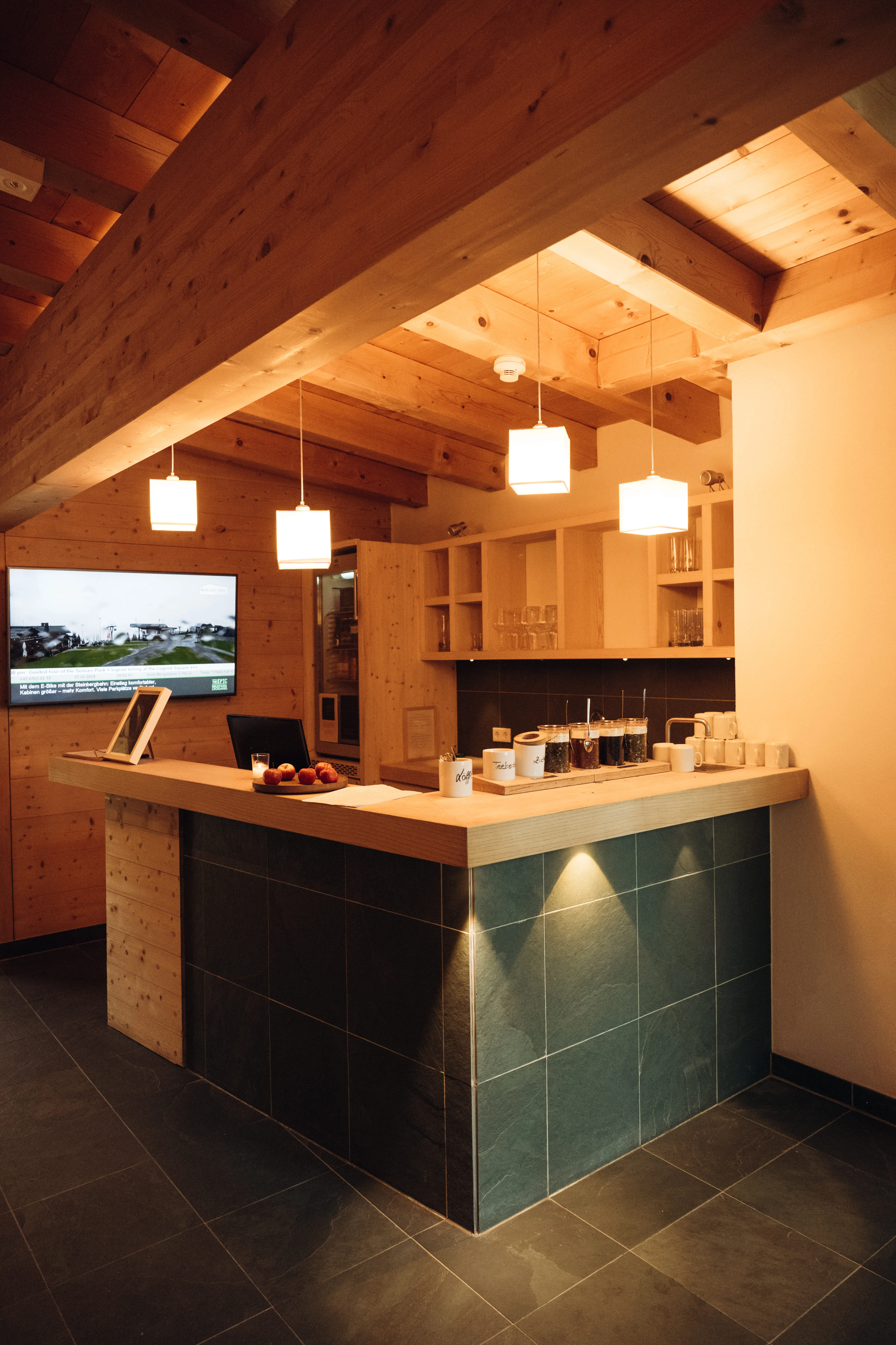 Modern reception area with a wooden ceiling and counter.