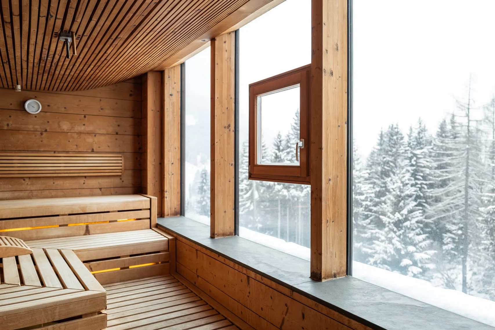 Sauna area in Holzhotel Forsthofalm in Leogang overlooking snowy trees
