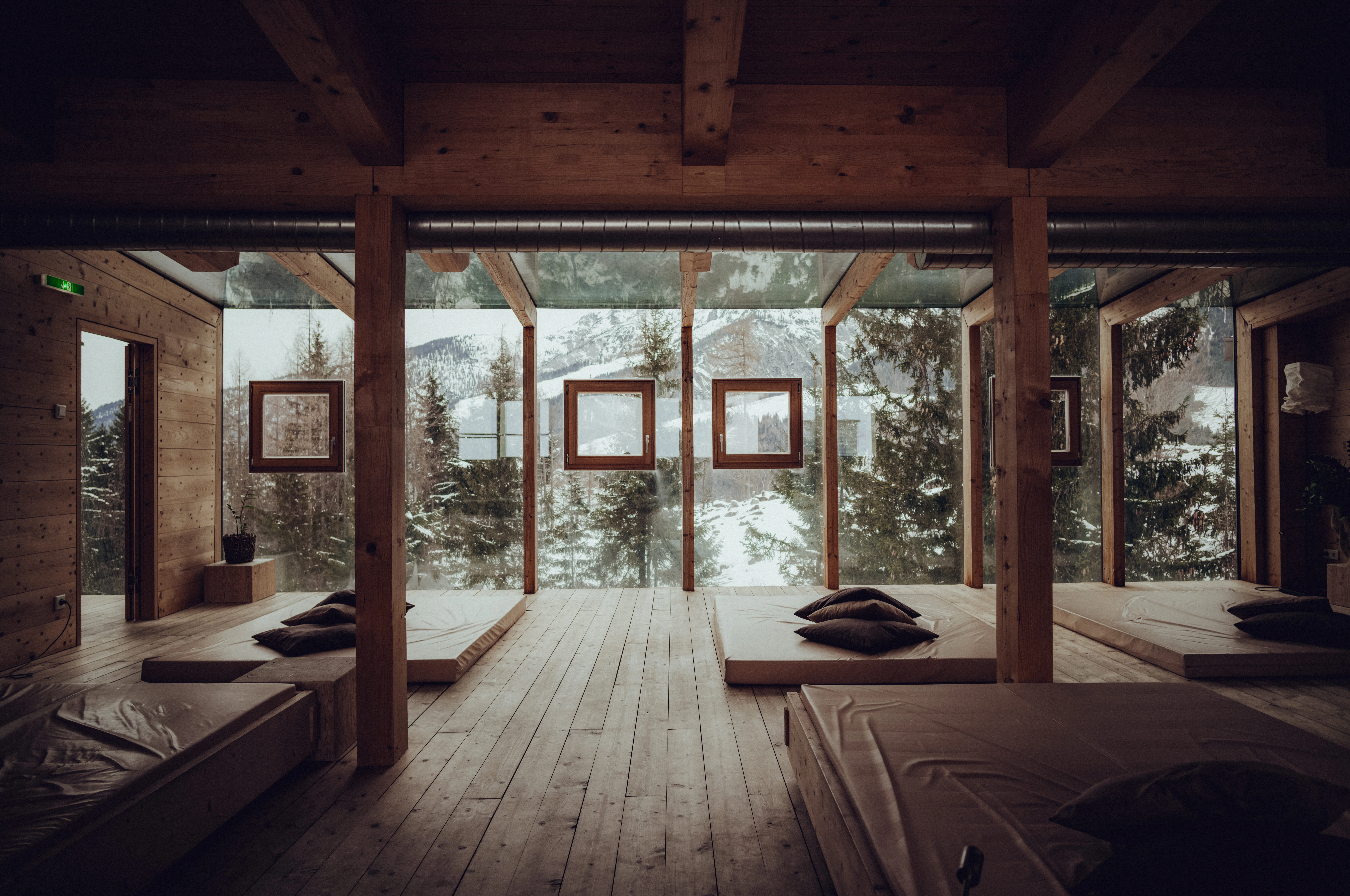 Modern wooden hotel interior with panoramic windows and minimalist furnishings.