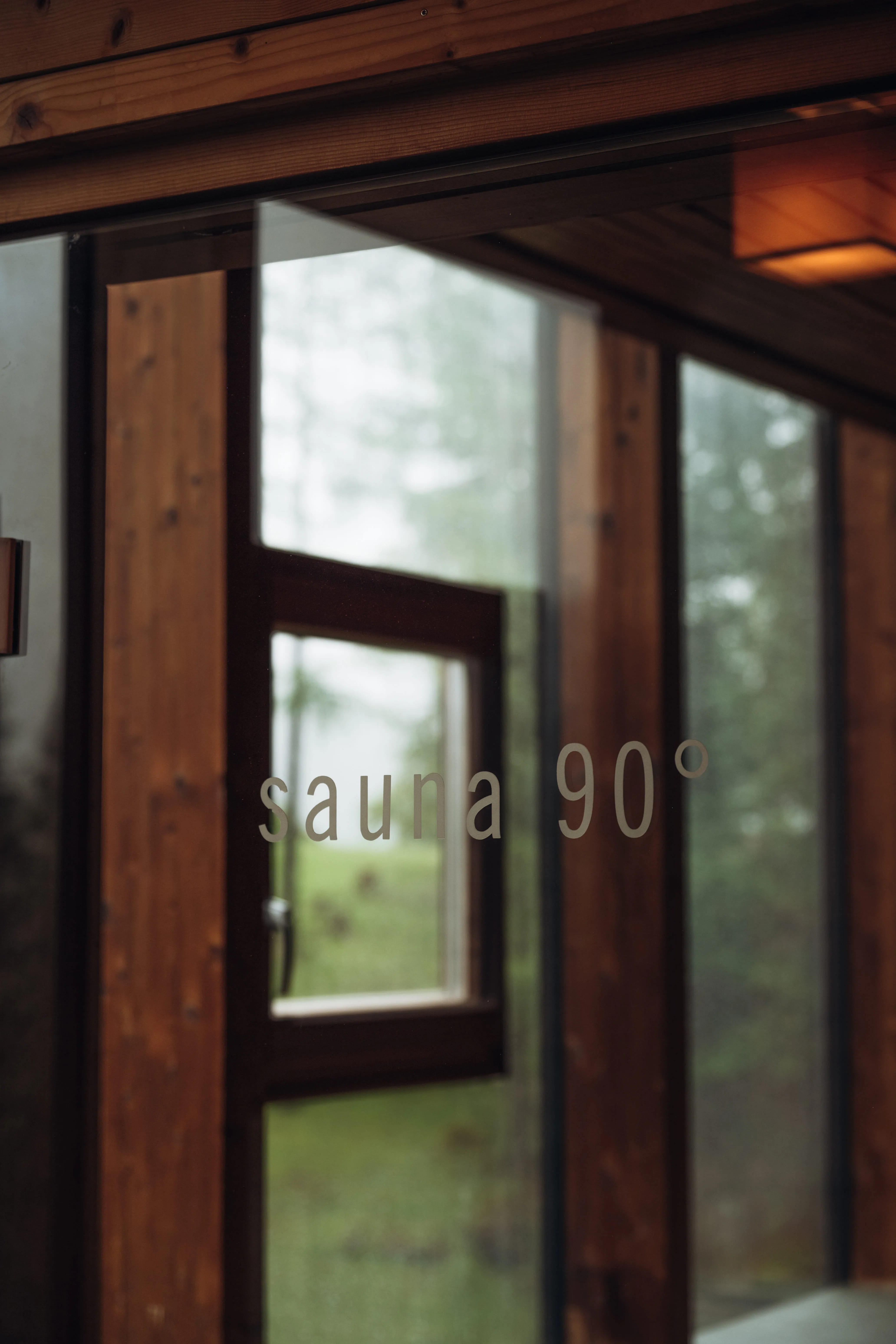 Glass door labeled 'sauna 90°' with a visible window