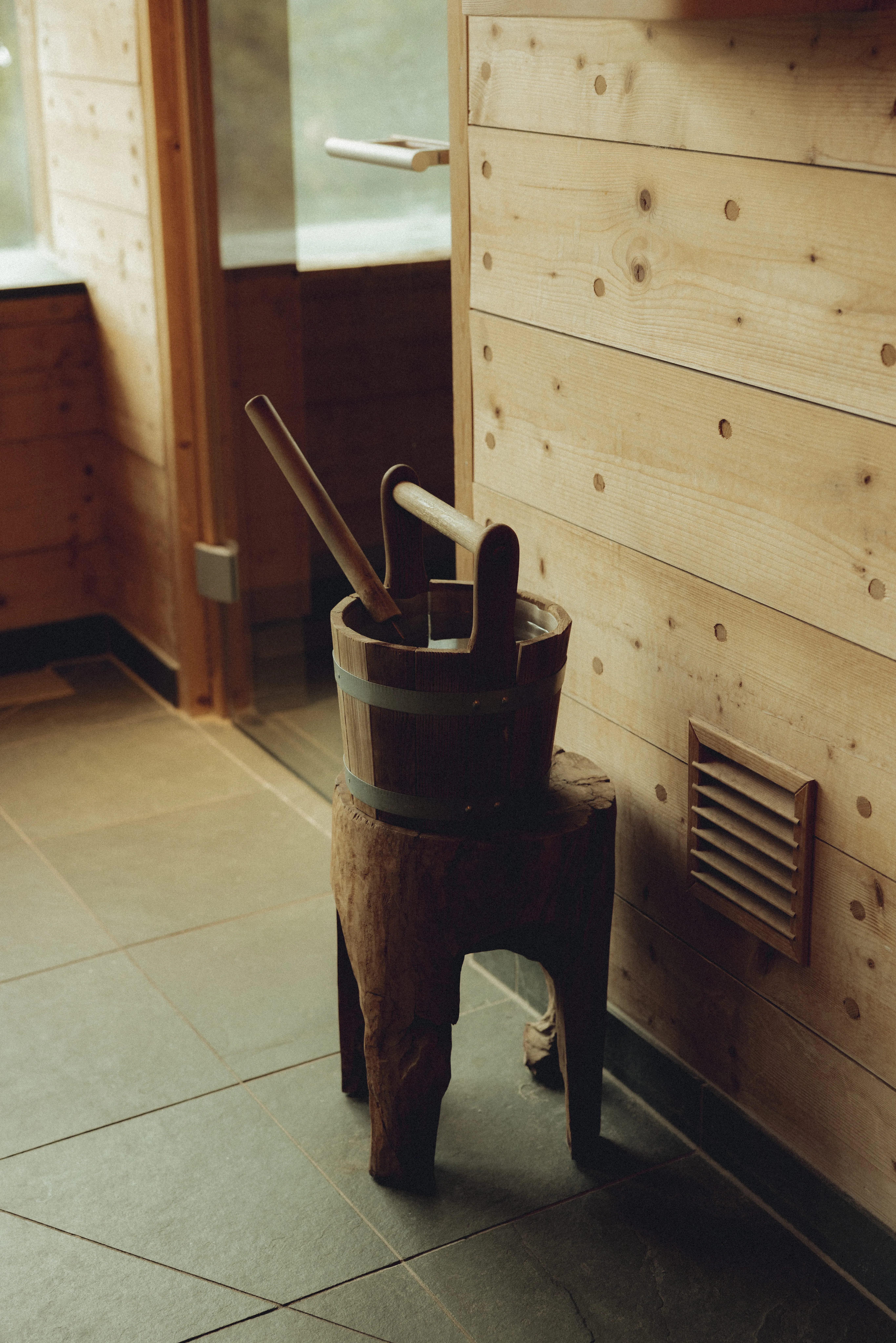 Wooden bucket with a ladle on a wooden stand in a modern interior