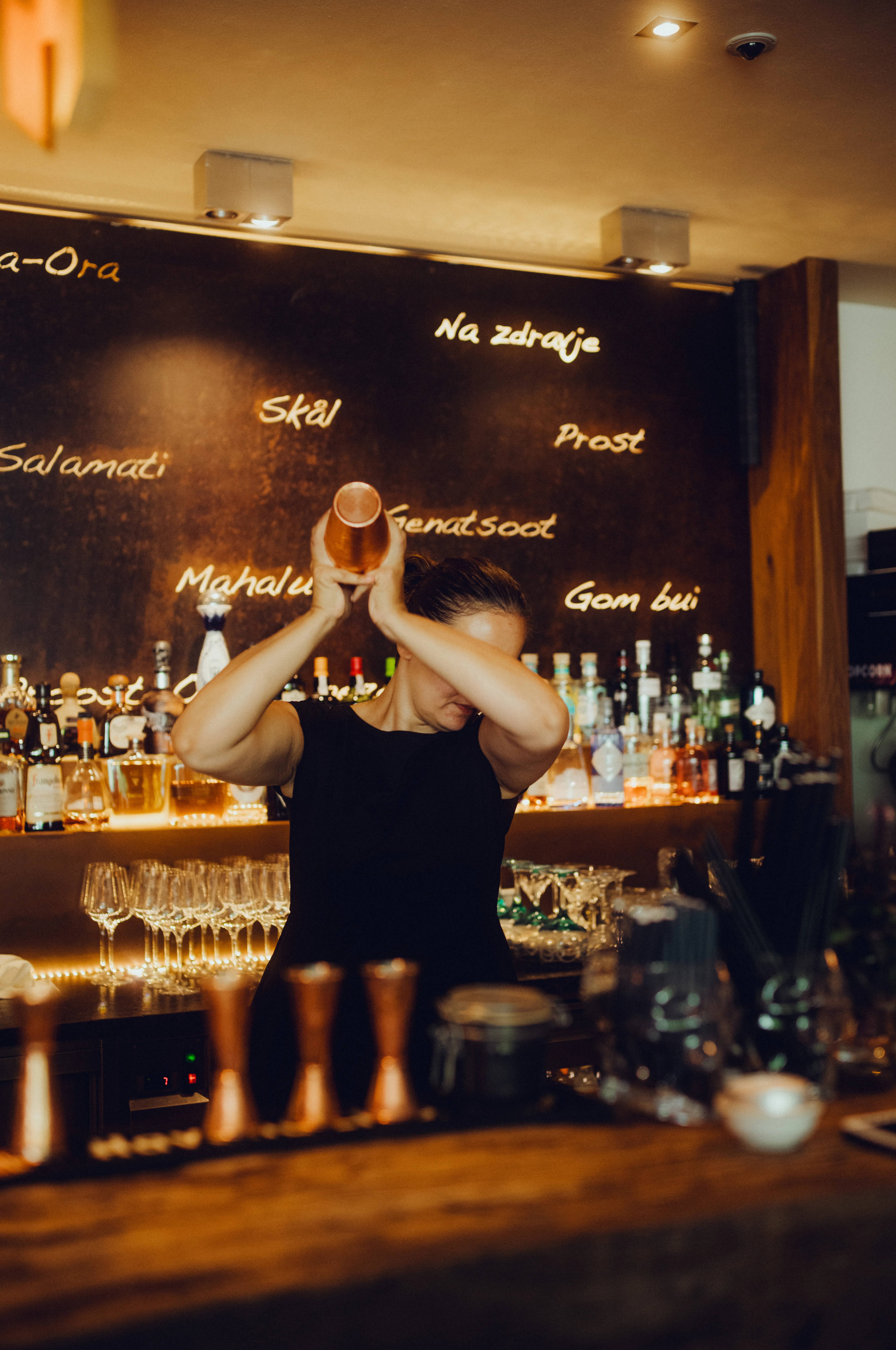 Bartender shaking a cocktail in a lively bar setting