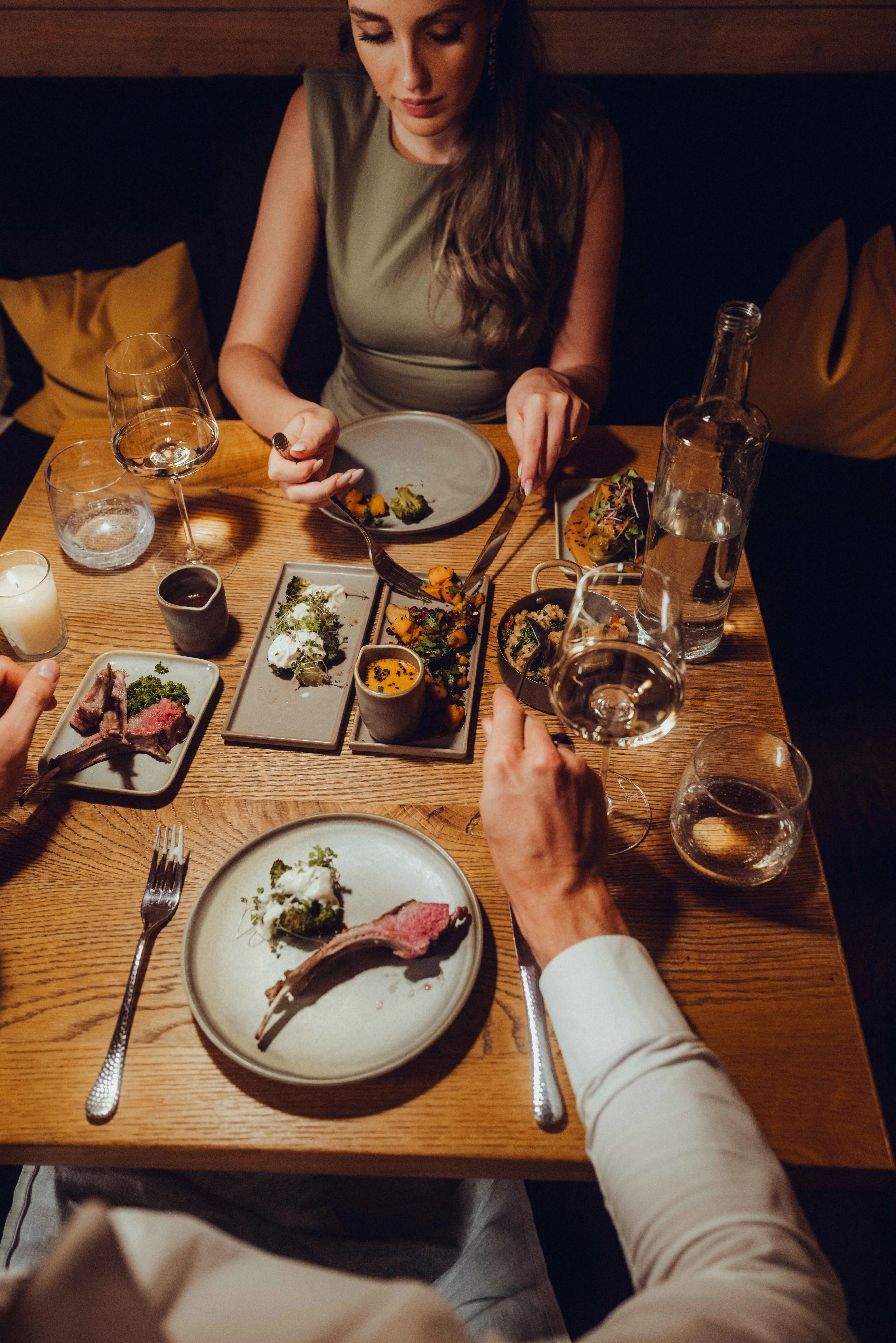 A table with various dishes and two people eating.