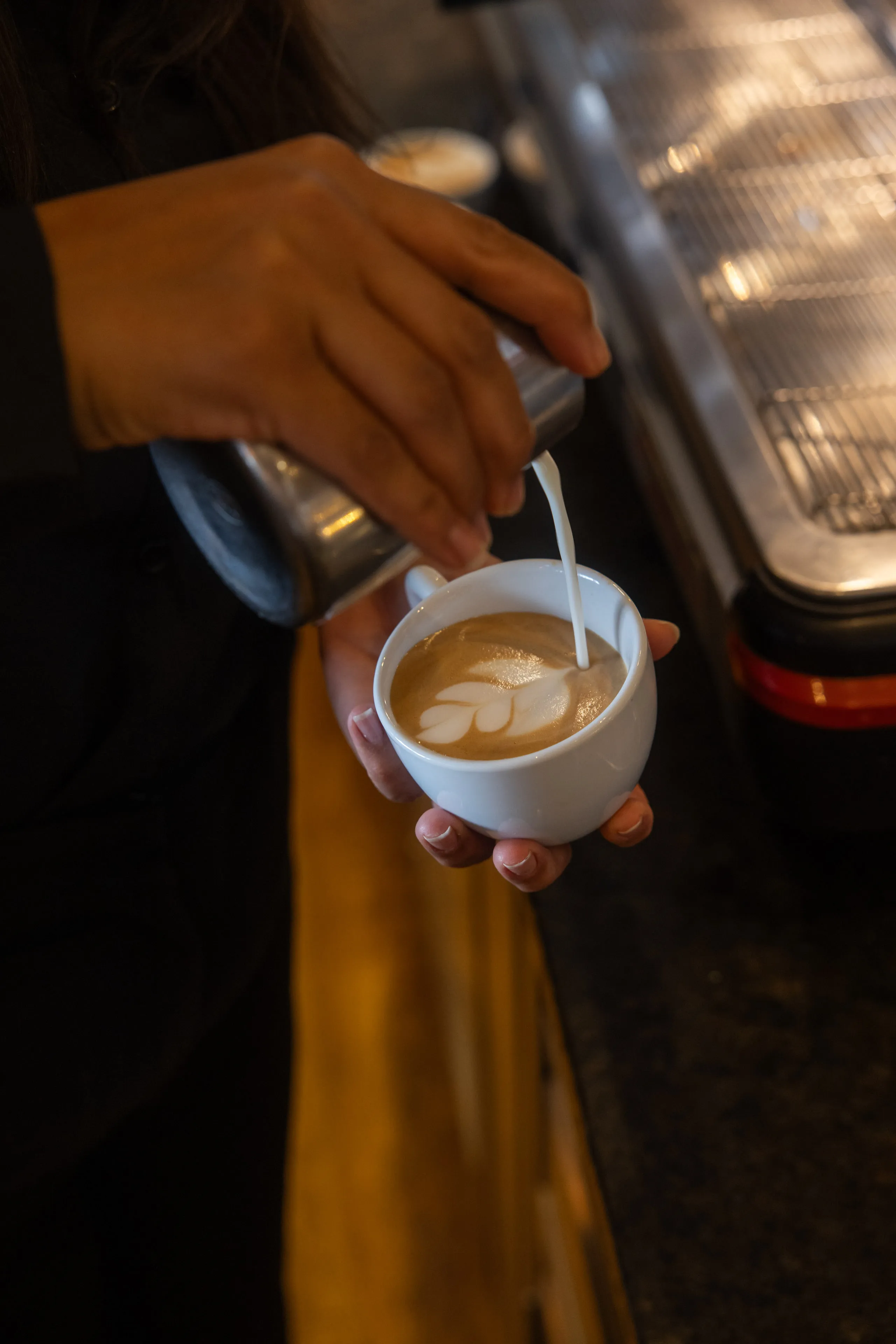 Barista gießt Latte Art in eine Tasse