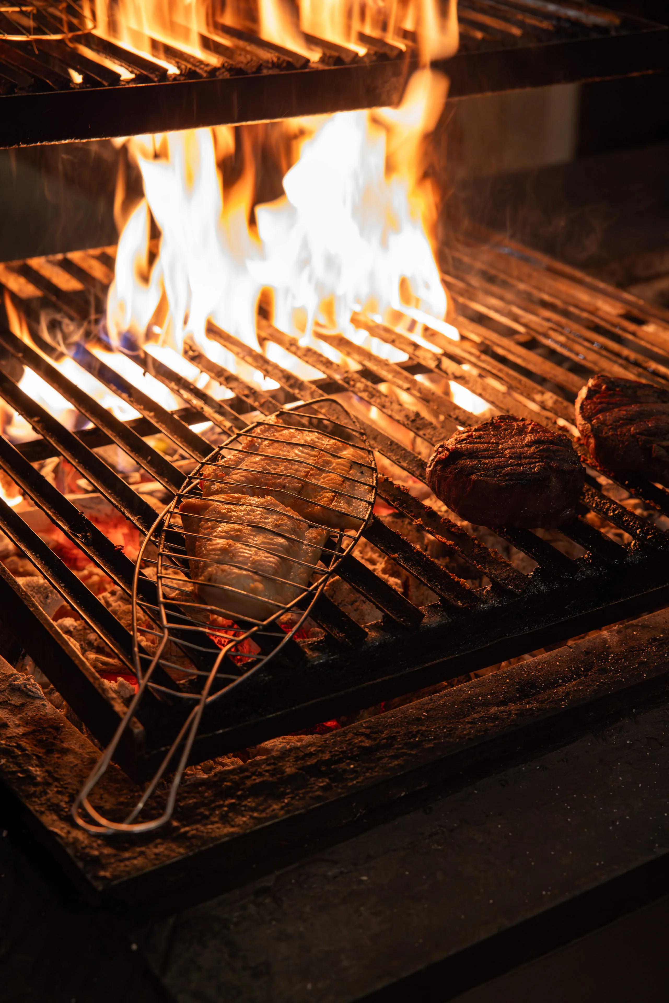 Grill mit Flammen und Fleischstücken