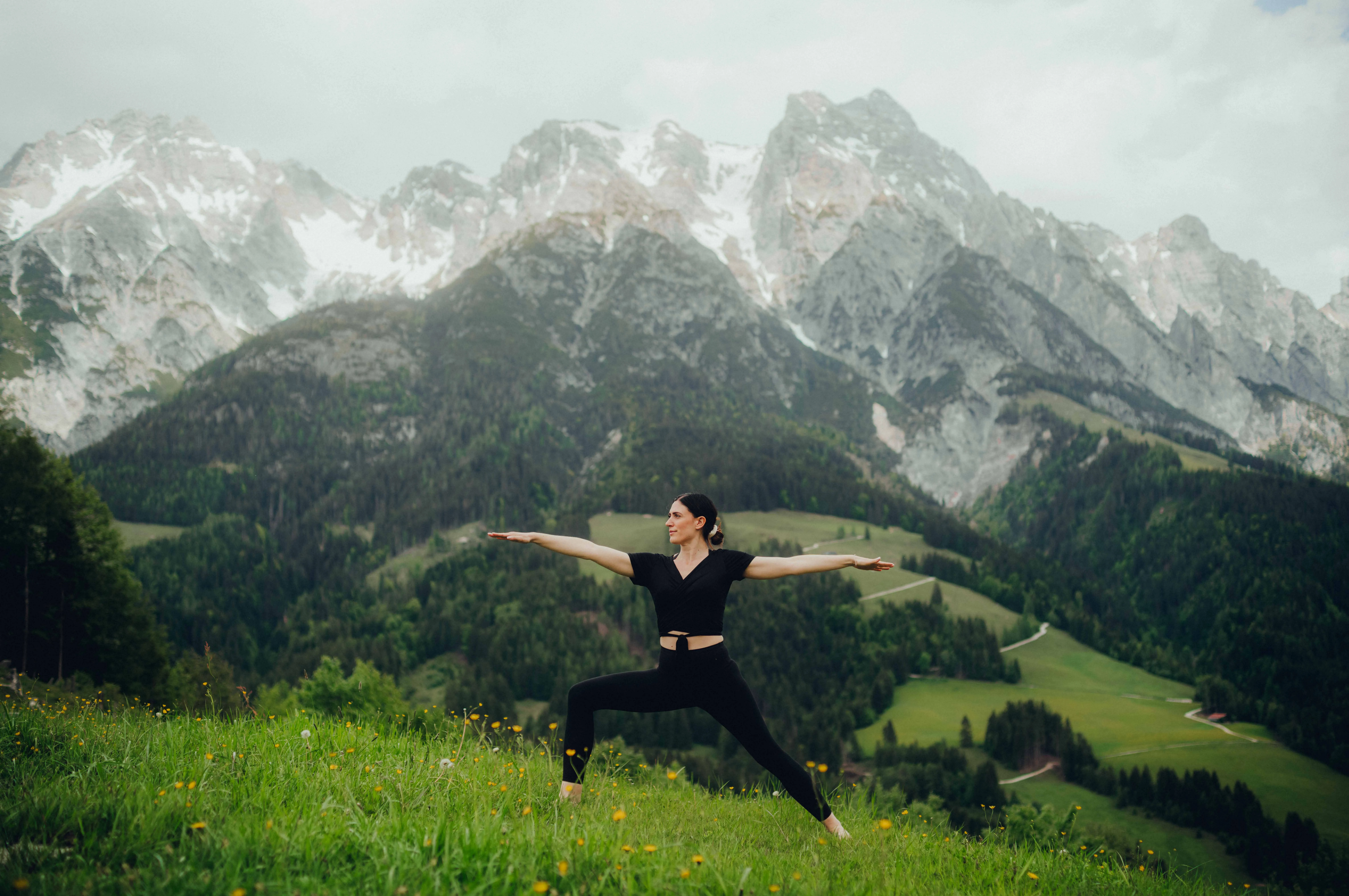 Woman in yoga pose against majestic mountain backdrop