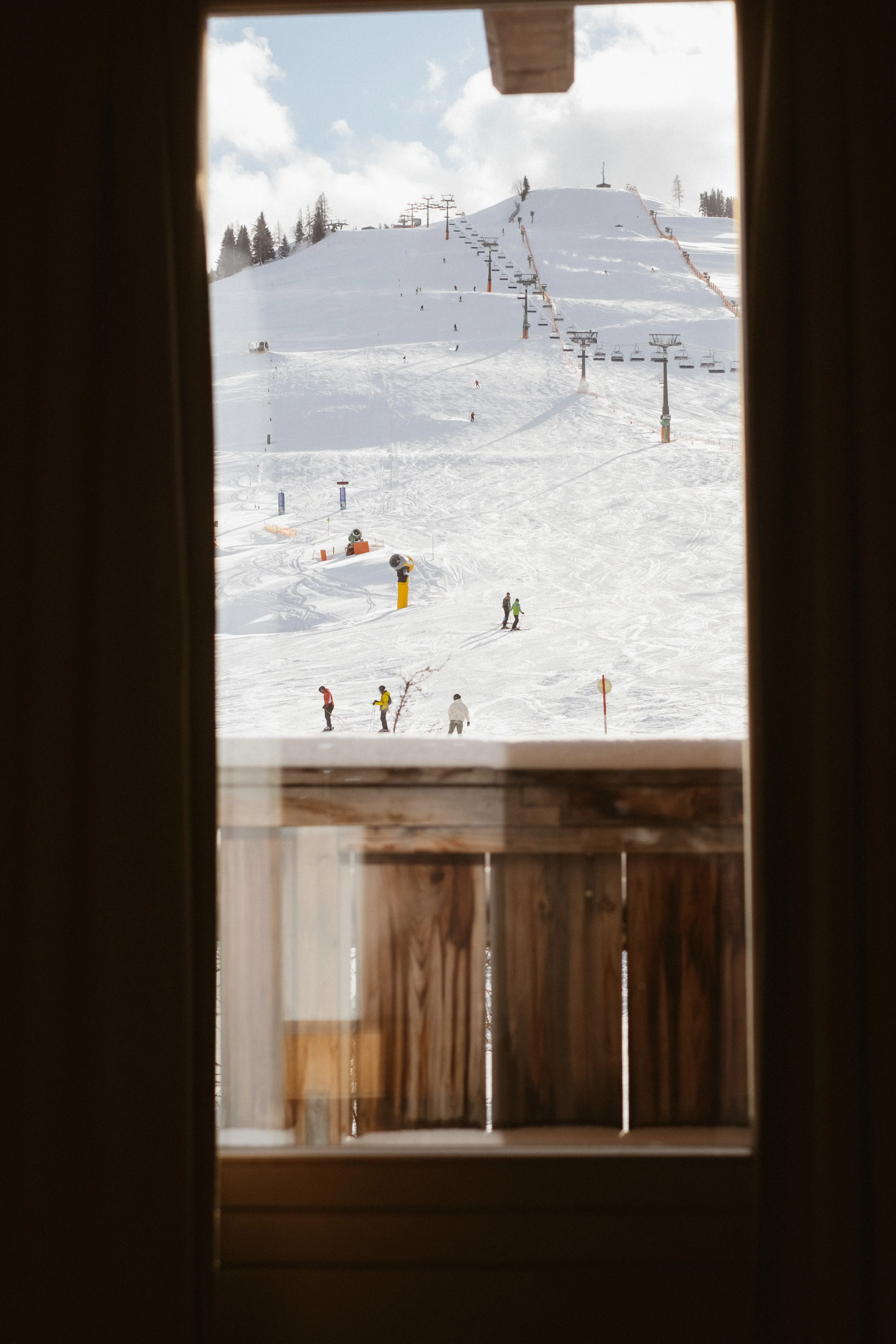 View of a snowy slope with skiers and a lift
