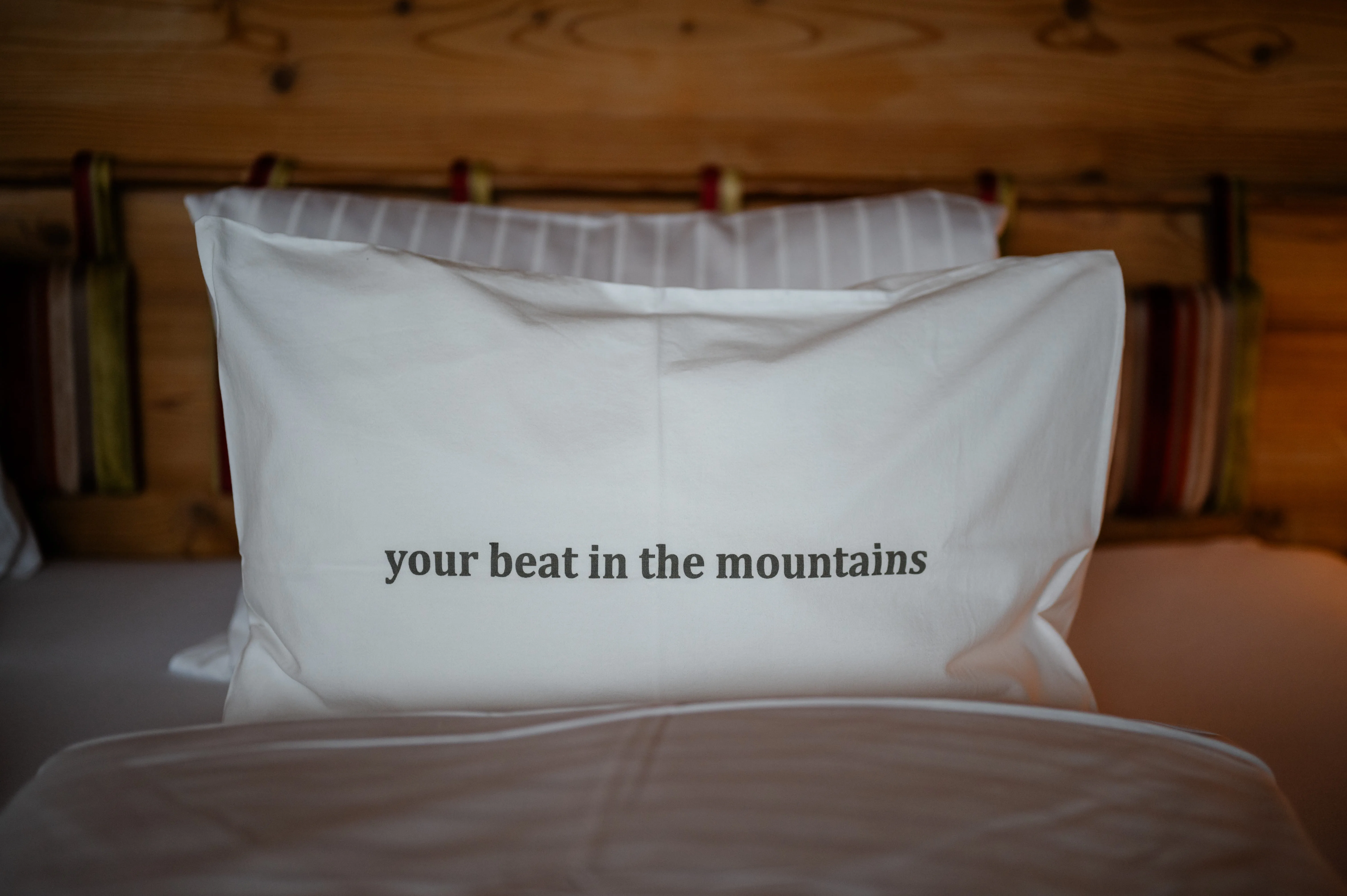Pillow with text 'your beat in the mountains' in Holzhotel Forsthofalm.