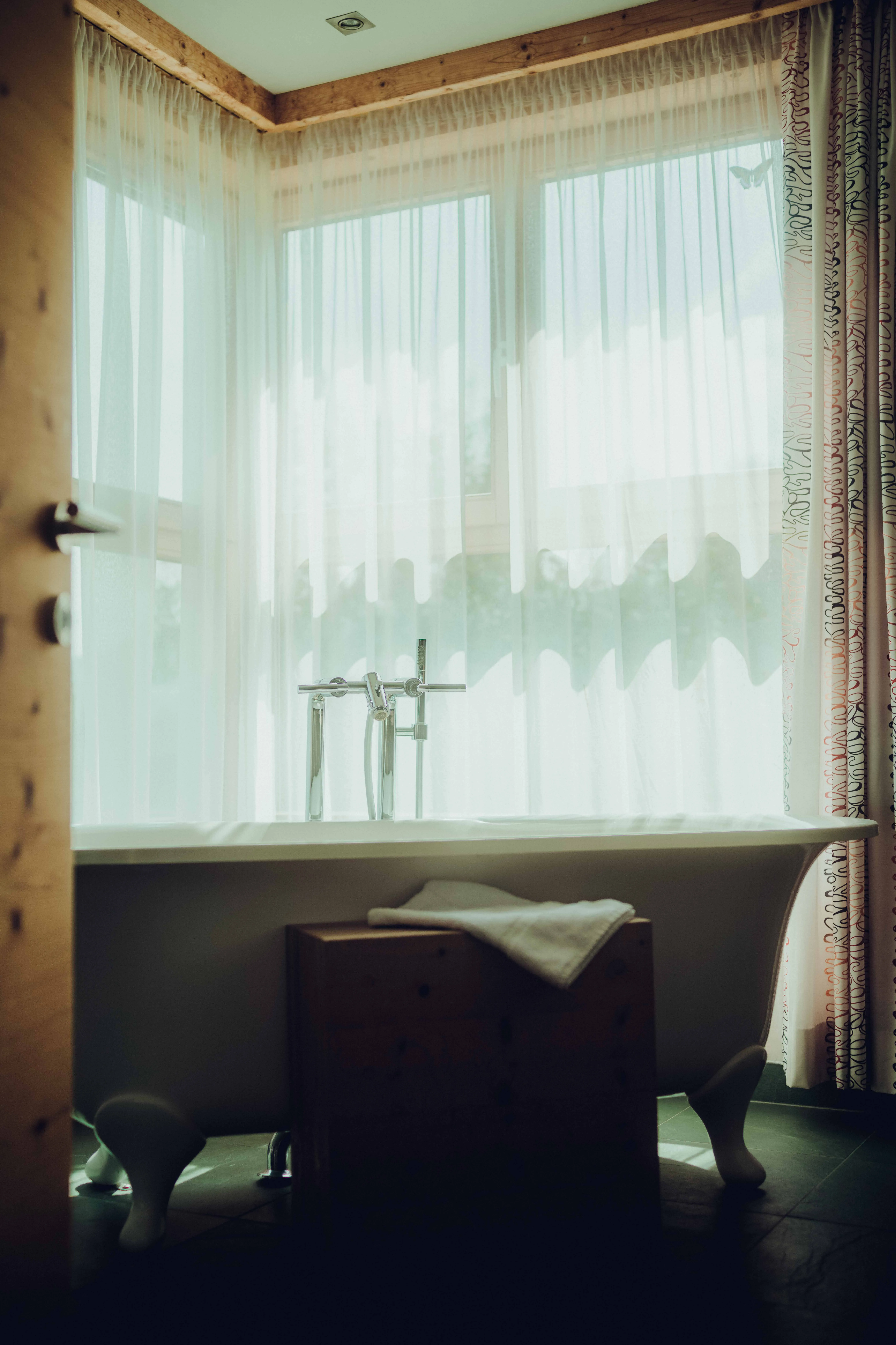 Bright bathroom with freestanding bathtub and window view