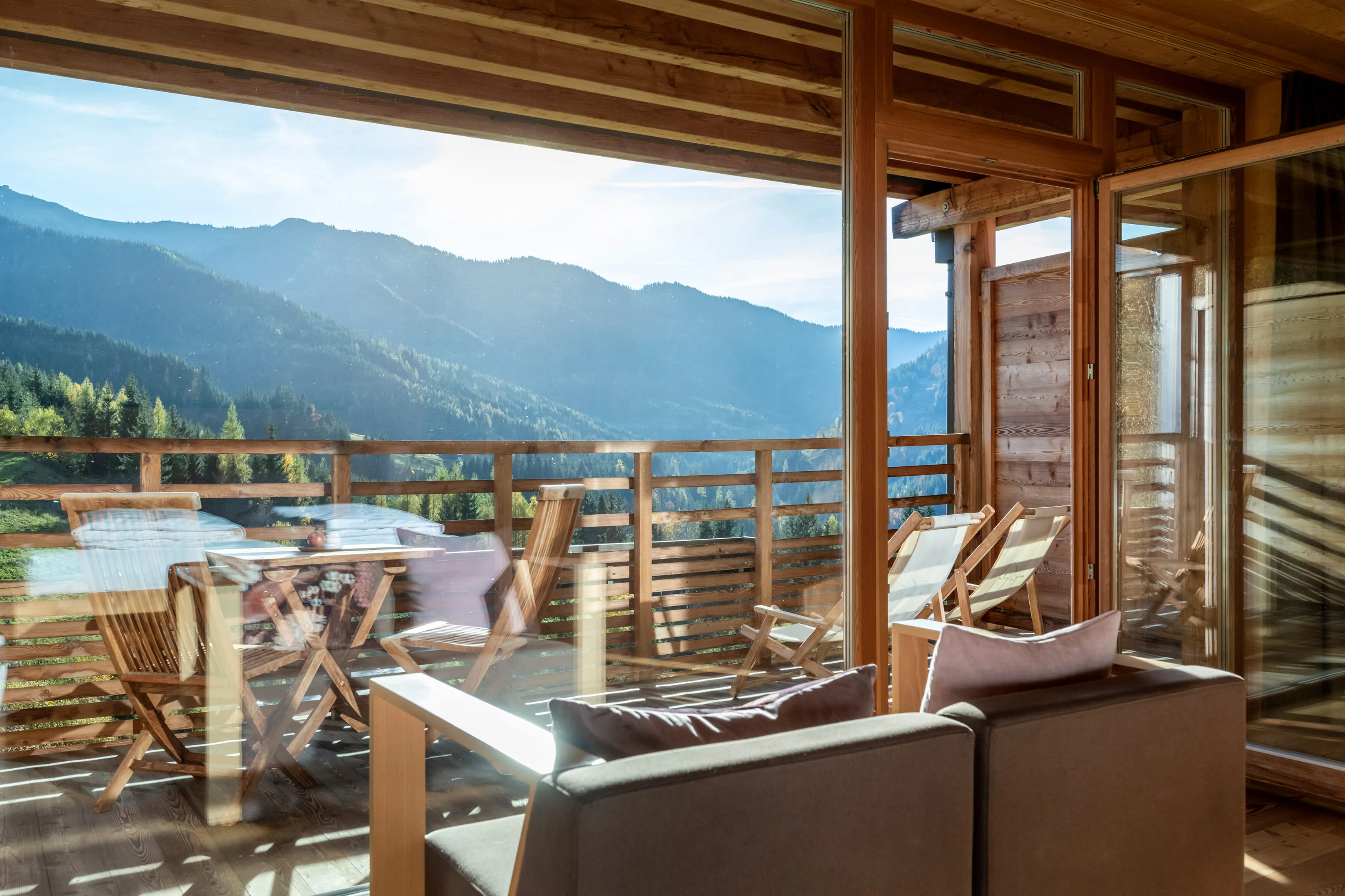 Balcony with wooden chairs and table, mountain view in Leogang