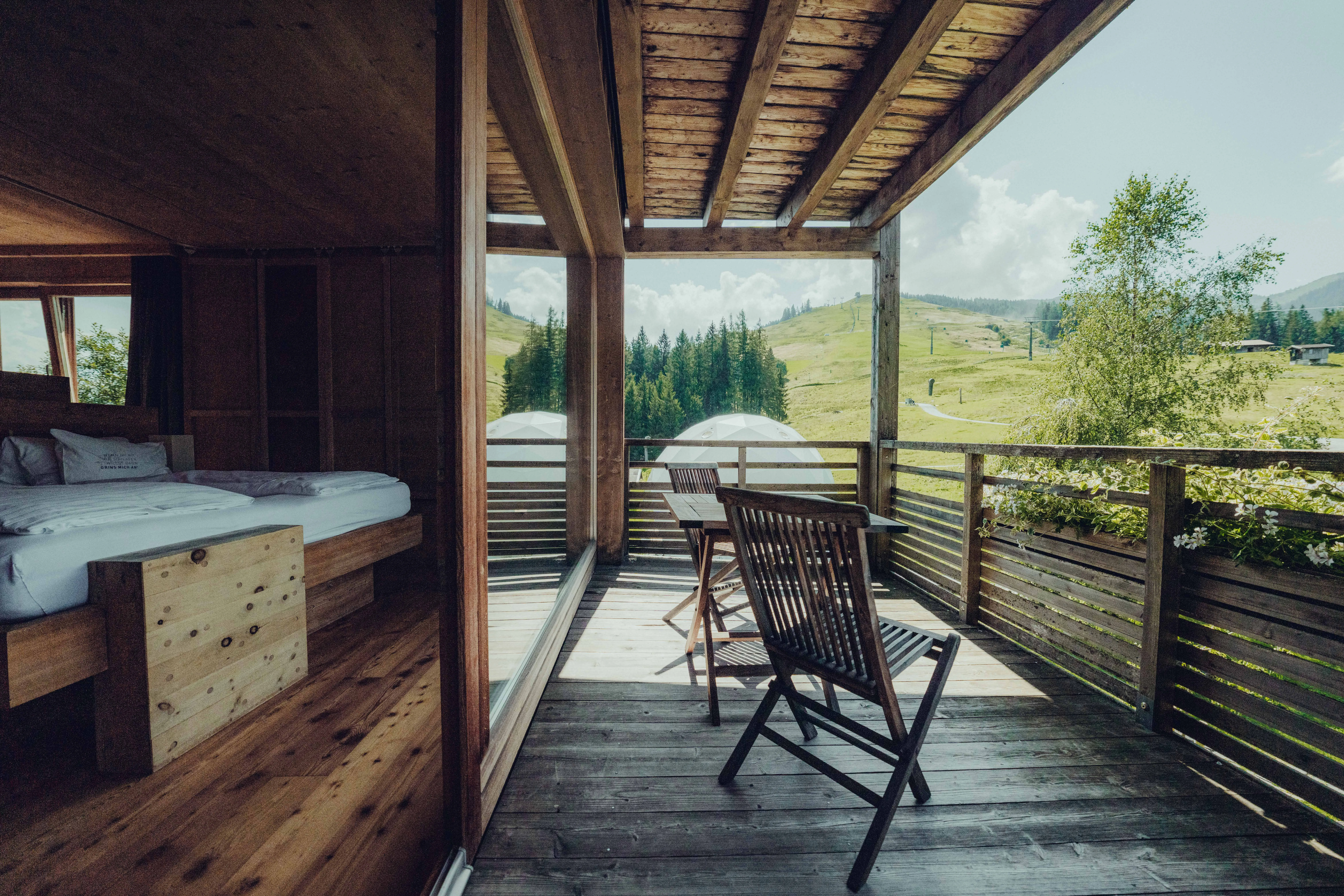 cozy room with wooden decor and balcony overlooking green hills