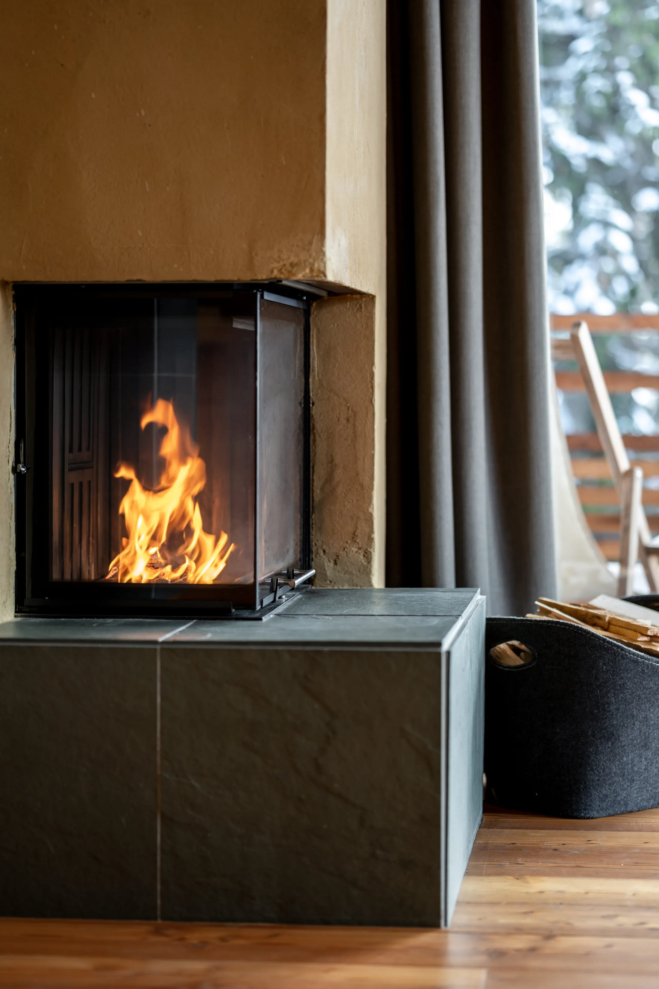Modern fireplace in a hotel room with a wood stack.