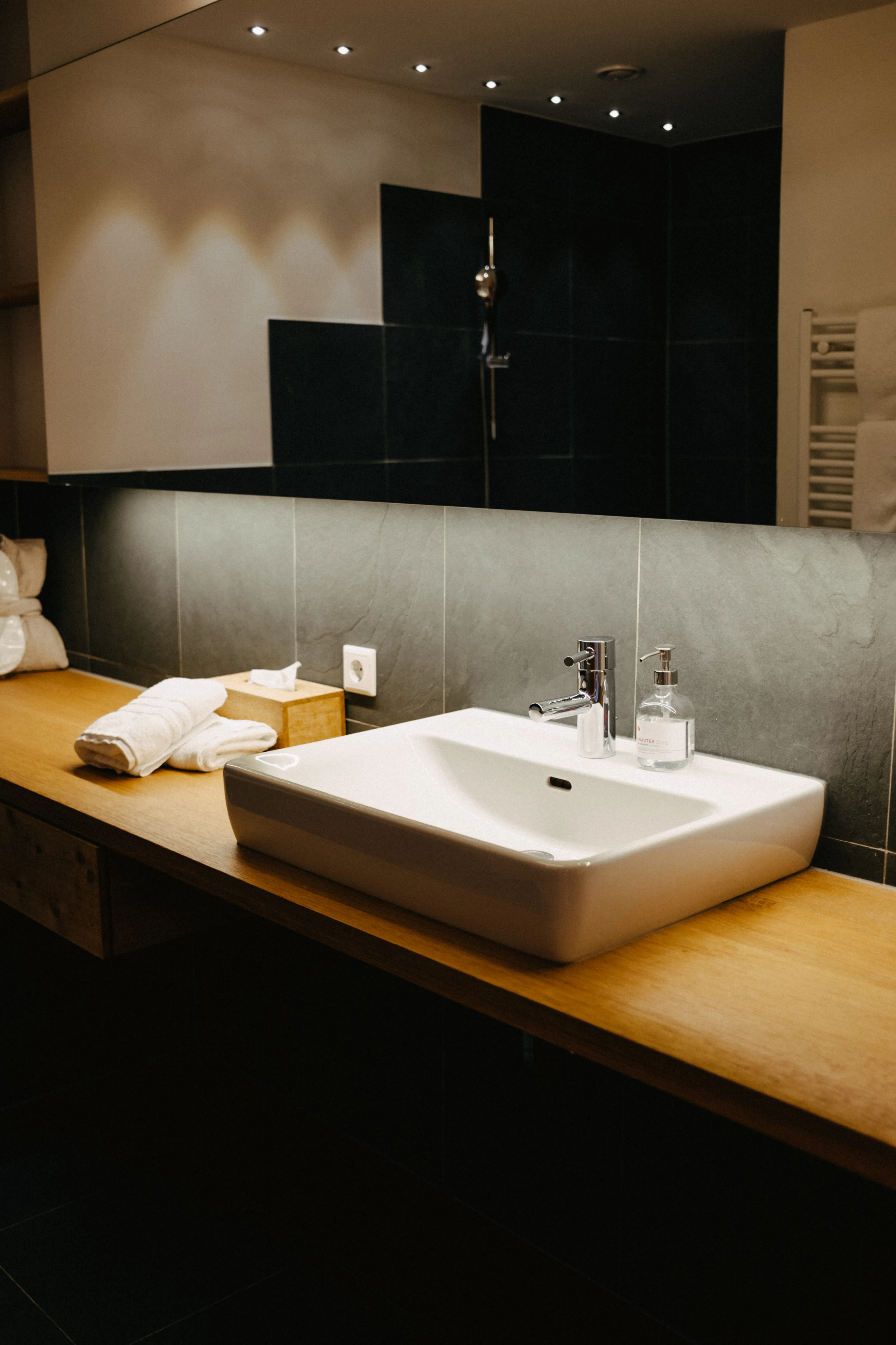 modern bathroom with a wooden counter and a white sink