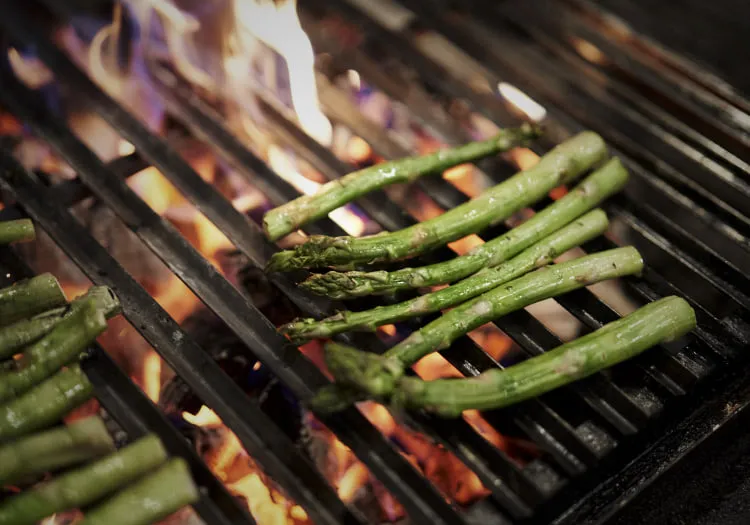 Gegrillter grüner Spargel auf dem Grillrost über offener Flamme