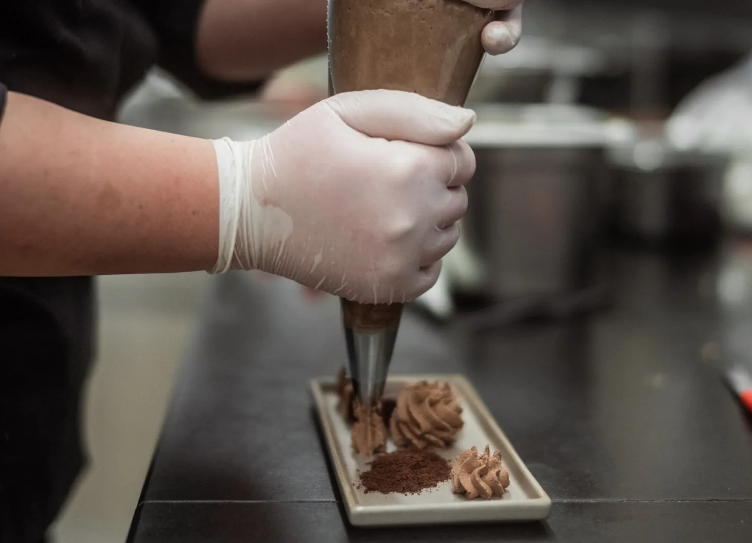 Küchenchef bereitet Dessert mit Spritzbeutel vor
